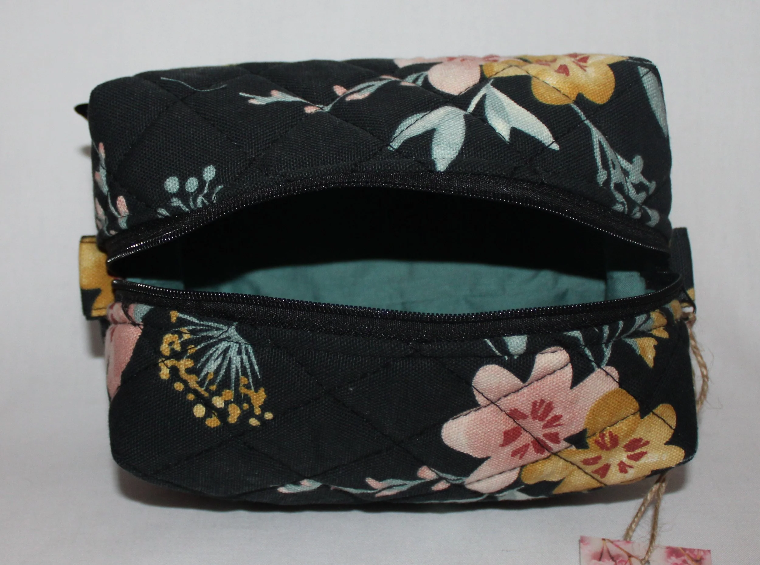 Top view of the open Twyla floral quilted travel pouch with the empty interior visible.