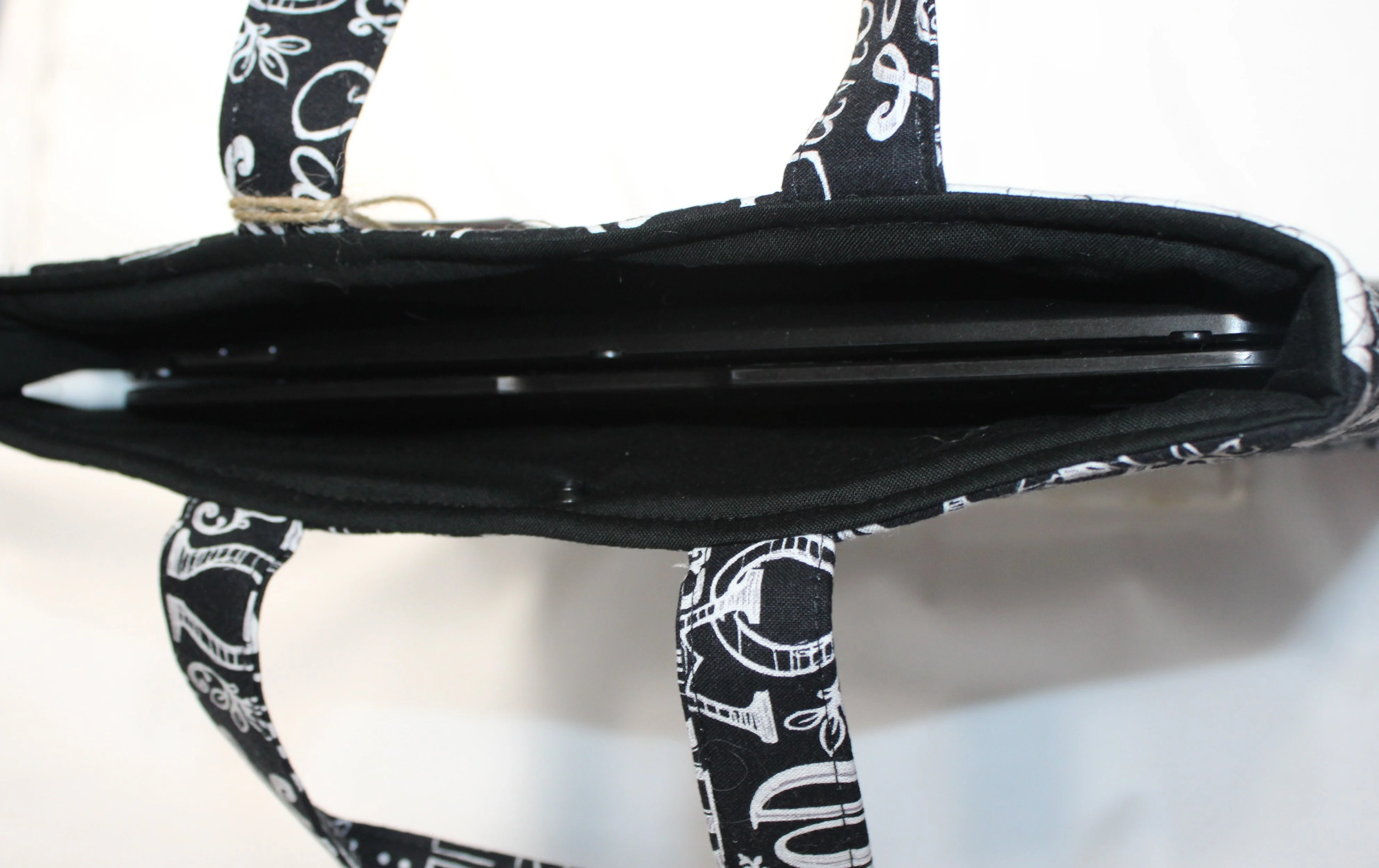 Top view of King of Kings quilted names of Jesus sleeve showing inserted tablet, two carry handles, and snap closure.