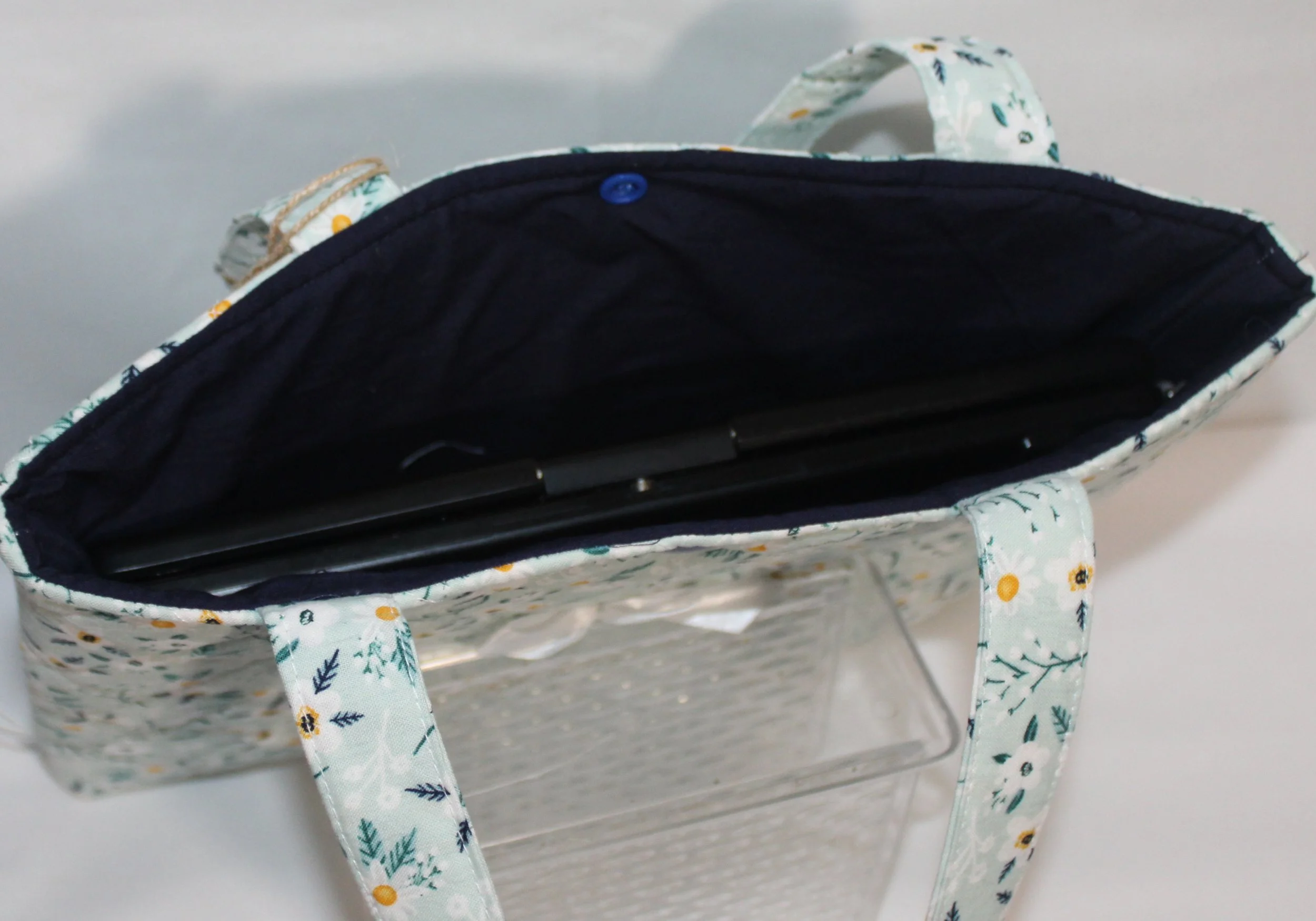 Top view of the Vera quilted tablet and book sleeve, showing a tablet inserted and the navy lining visible.