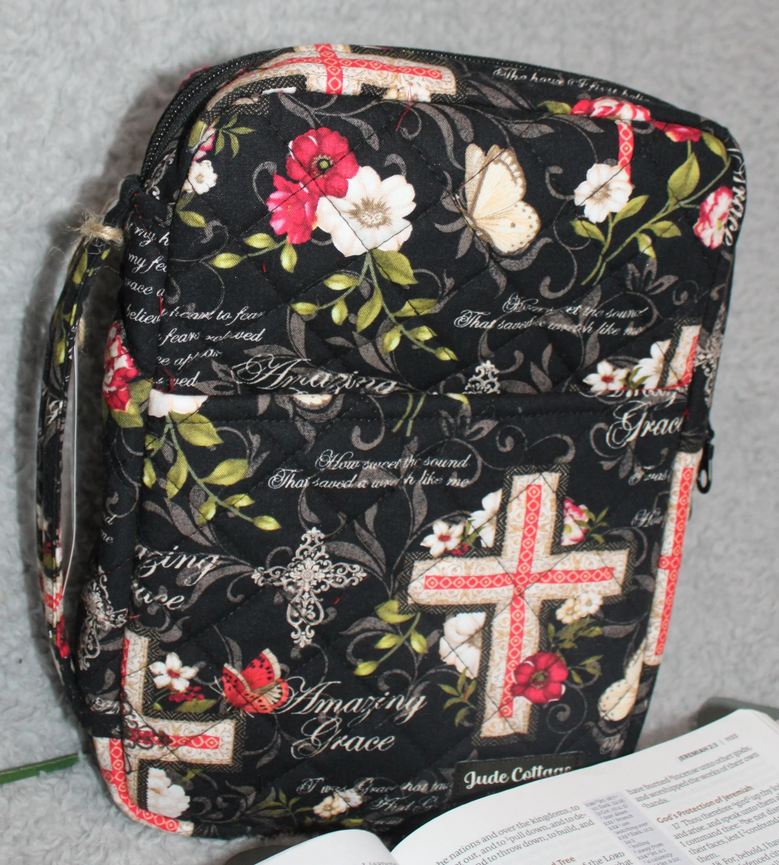 Side view of the Amazing Grace Bible case showing the quilted red and white floral fabric and the sturdy padded handle.