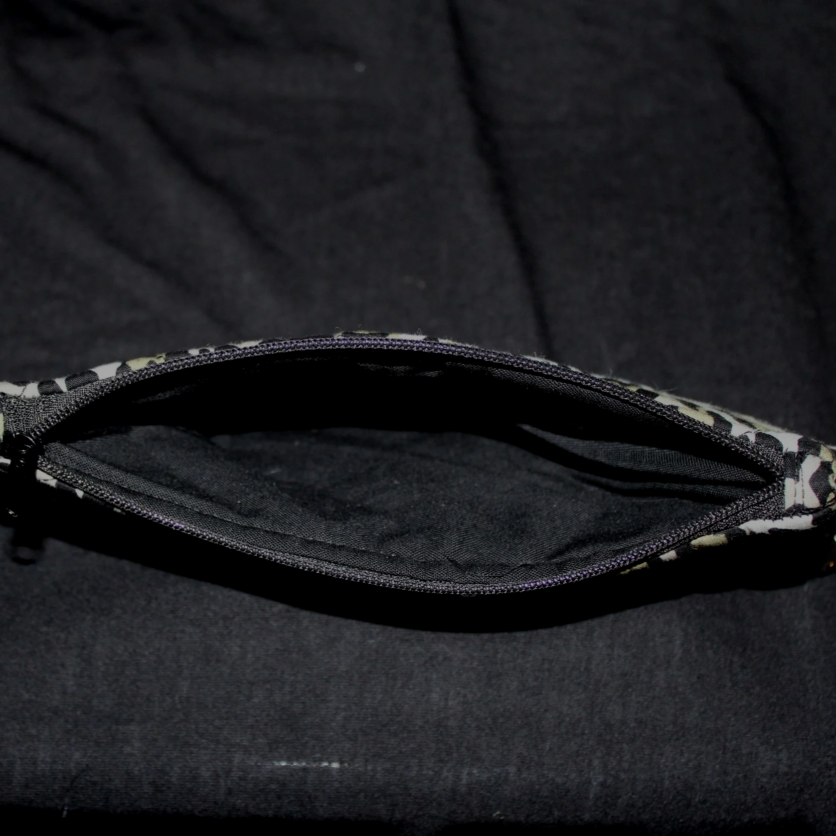 Top open view of the Diana Large Keychain Wallet showing the black zip closure and lining.