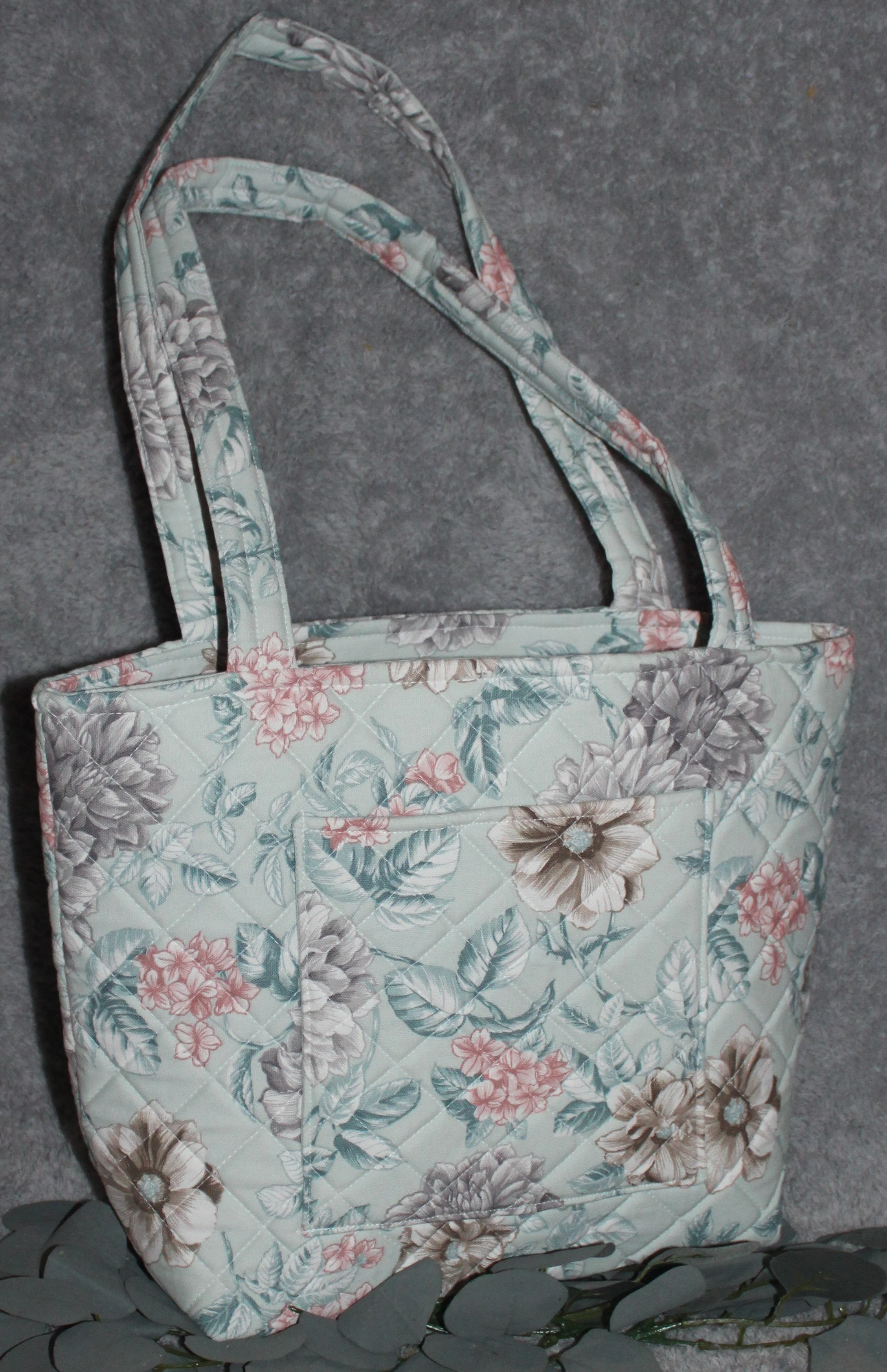 Back view of the Joelle quilted tote bag showing back slip pocket, quilted design, and two handles.