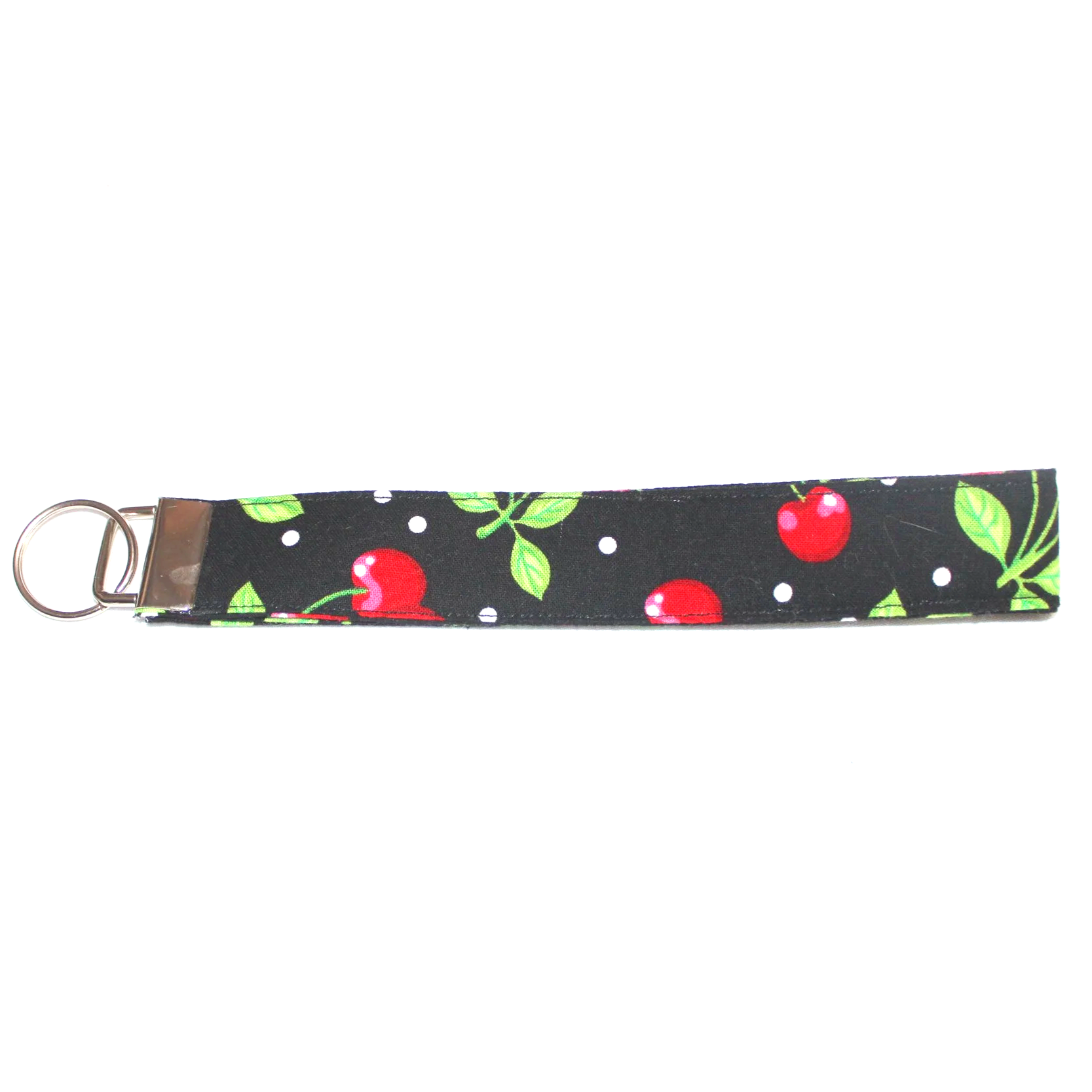 Close up view of the Scattered Cherry Wristlet showing the black background with white polka dots, red cherries, and green leaves and stems.
