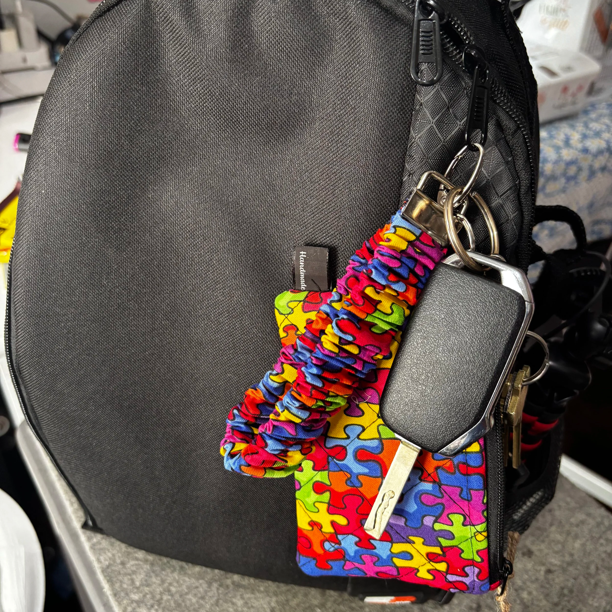 Autism Awareness Wallet Set featuring puzzle piece fabric shown clipped to a bag.