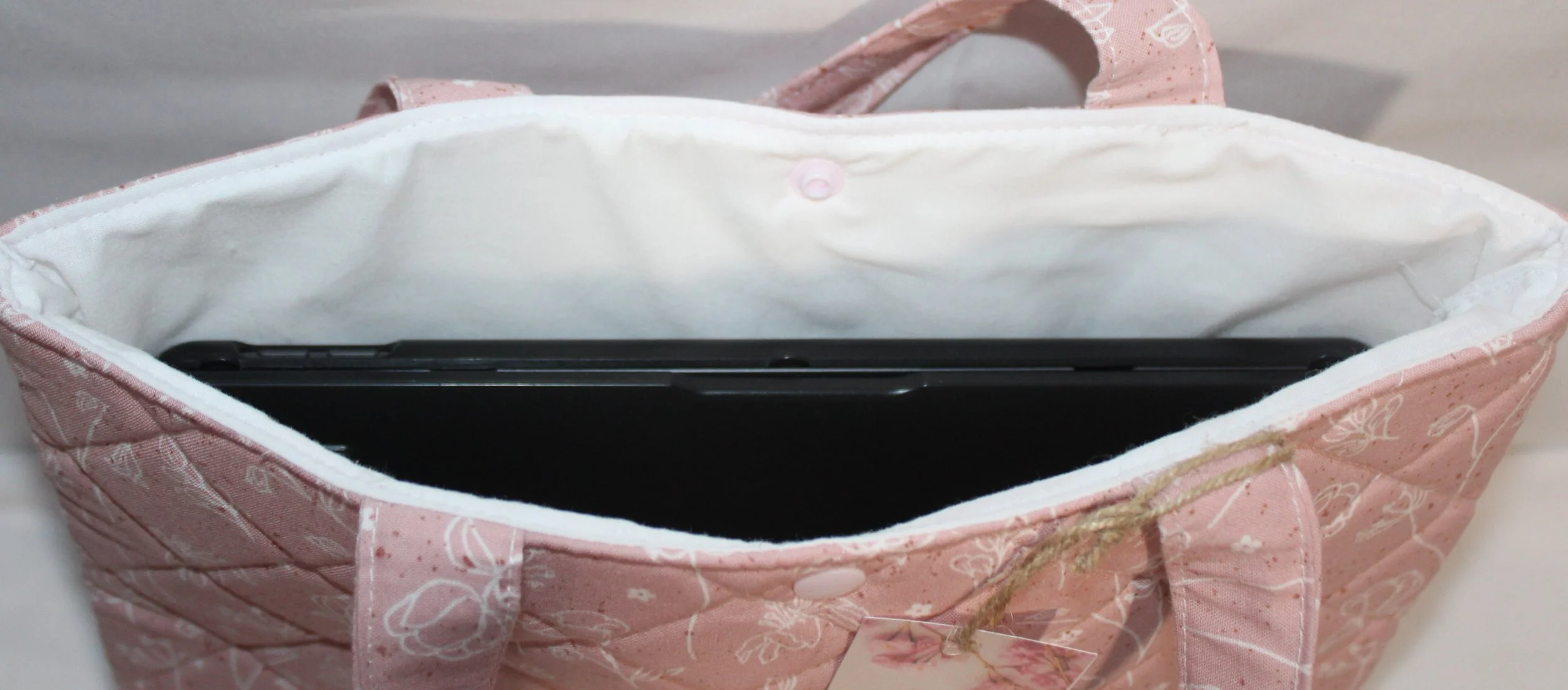 Top view of Pink Dreams quilted tablet and book sleeve shown upright with tablet inside.