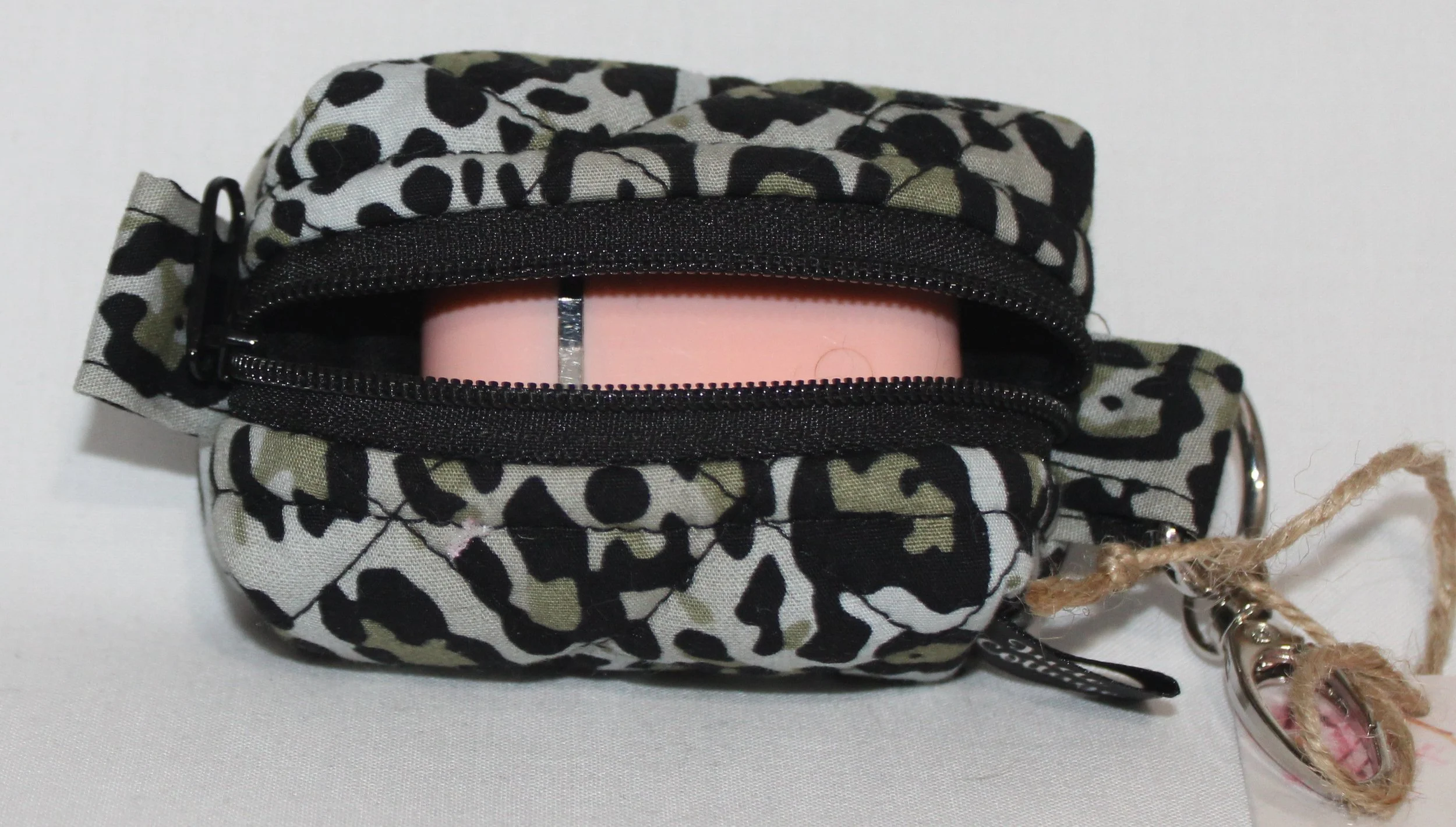 Open top view of the Diana Bag Charm featuring snow leopard print showing a set of Airpod earbuds inserted for sizing.