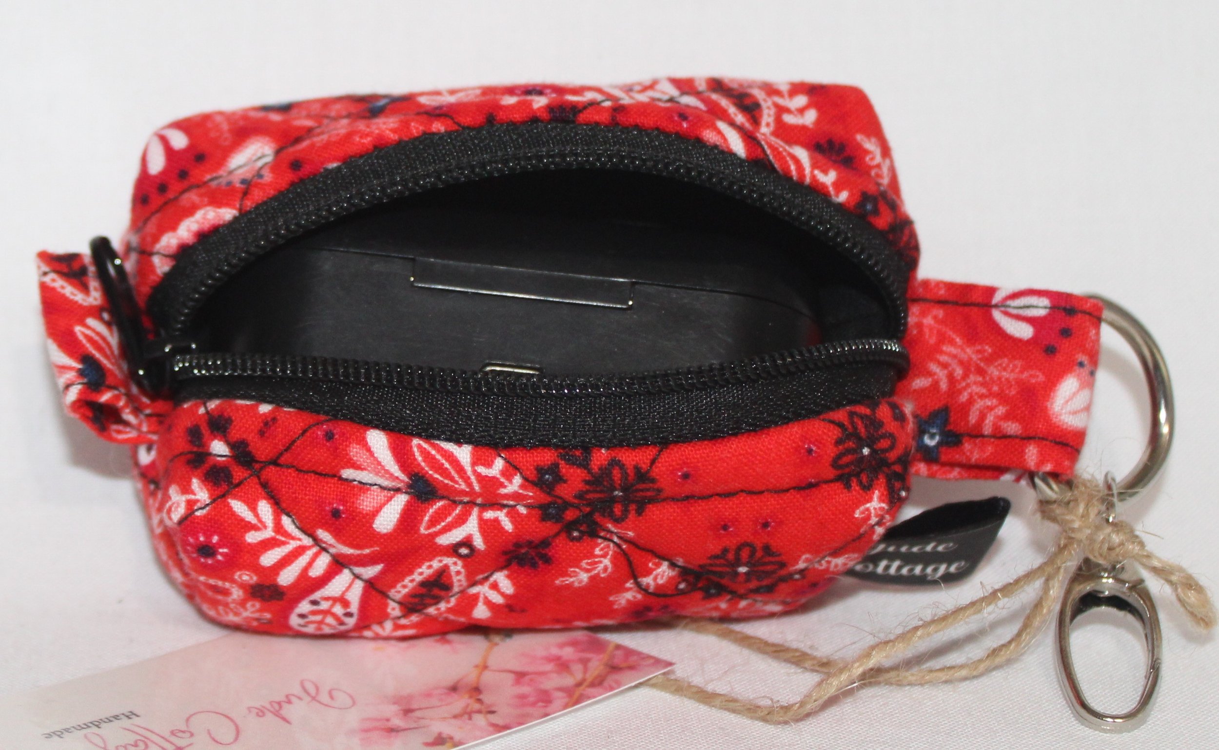 Top open view of the Freedom Red Bag Charm featuring red background with floral and paisley print fabric, shown with an Airpod Pro earbud case inserted to demonstrate fit.