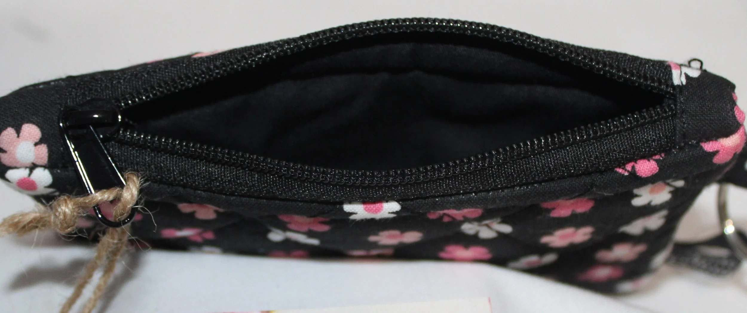 Top view of Ditzy Pink quilted keychain wallet with small ditzy floral pattern, zipper closure.