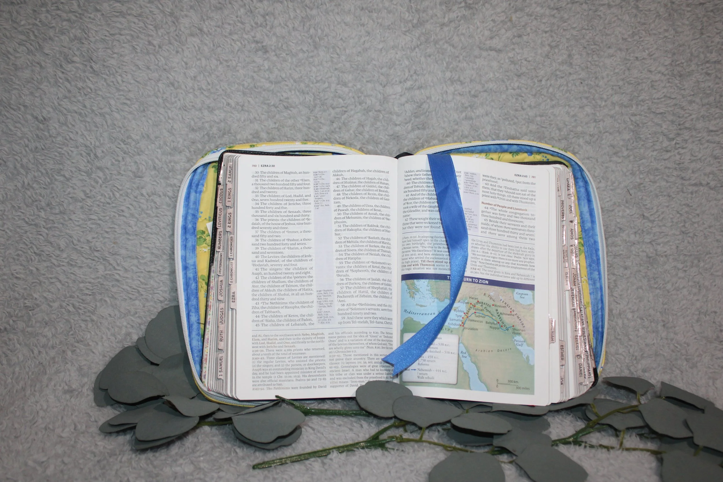 Interior view of the Flora Quilted Bible Study Case with a Bible inserted, showing the floral lining, pen holders, and ribbon marker across the open pages.