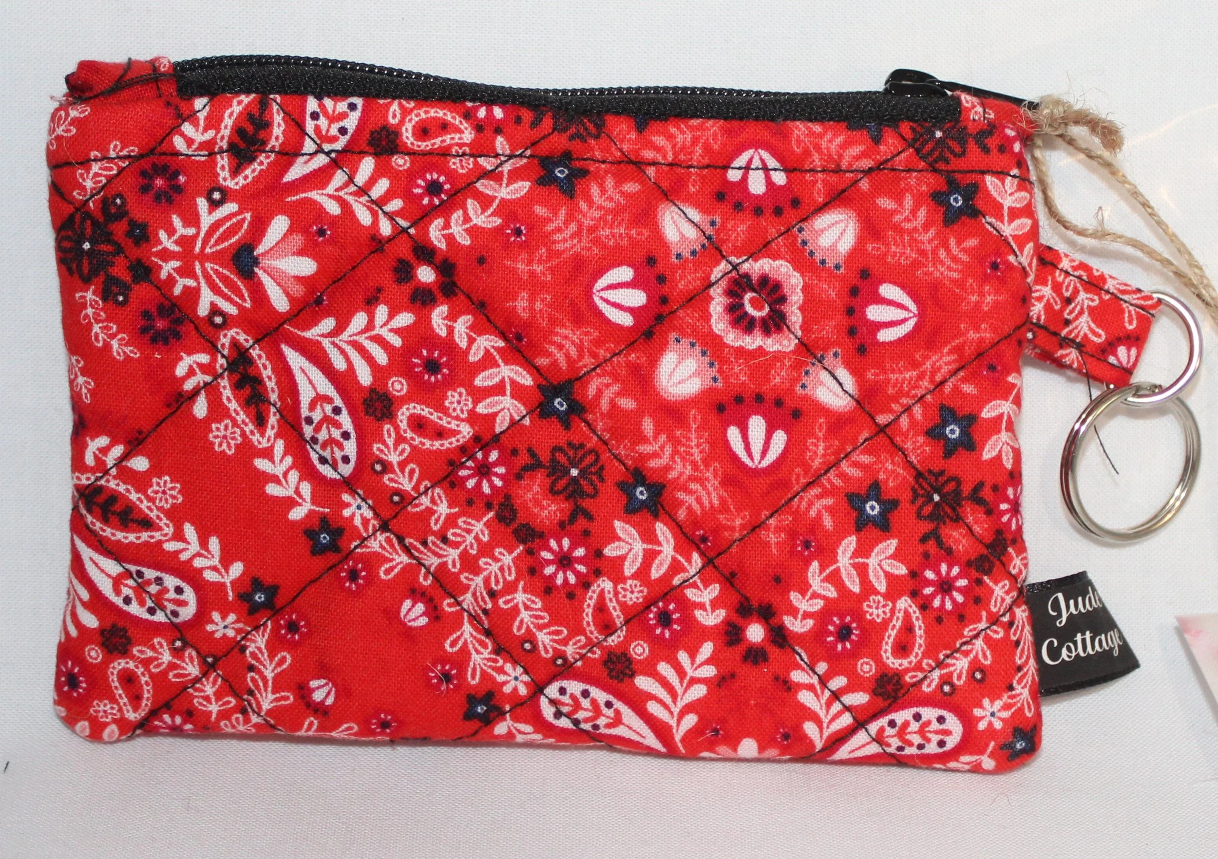 Red quilted keychain wallet with patriotic pattern, zipper closure, and metal key ring.