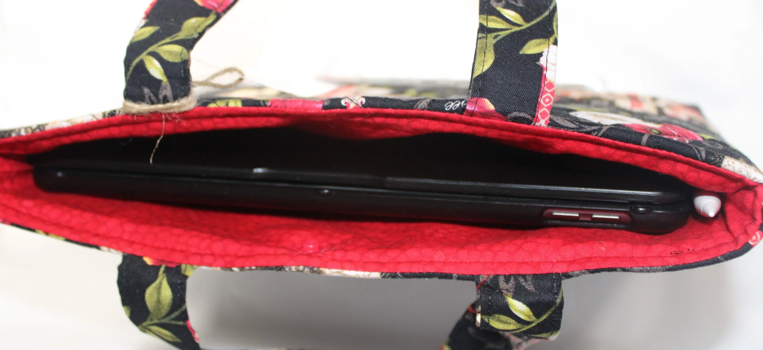 Top view of Amazing Grace quilted floral sleeve with tablet inserted showing snap closure.