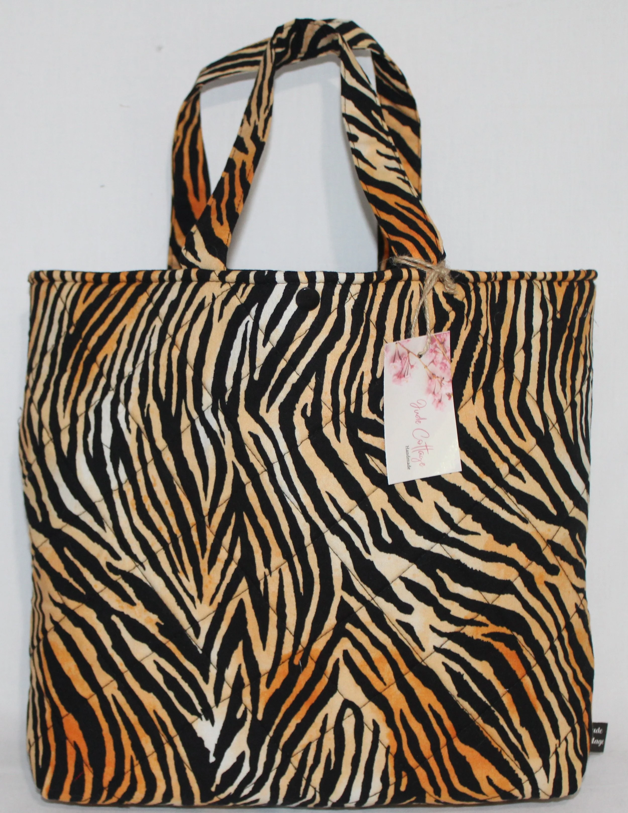 Front view of the Zara quilted Bible sleeve with tiger print fabric showing the two handles and snap closure.