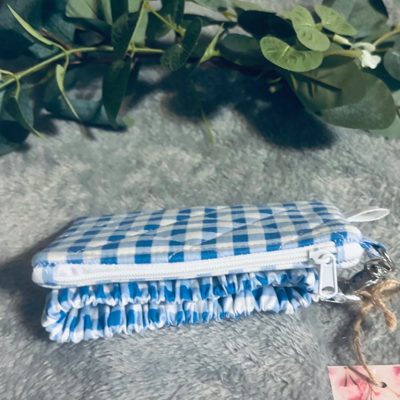 Closed top view of the Annabeth Keychain wallet featuring a white zipper with blue and white gingham print.