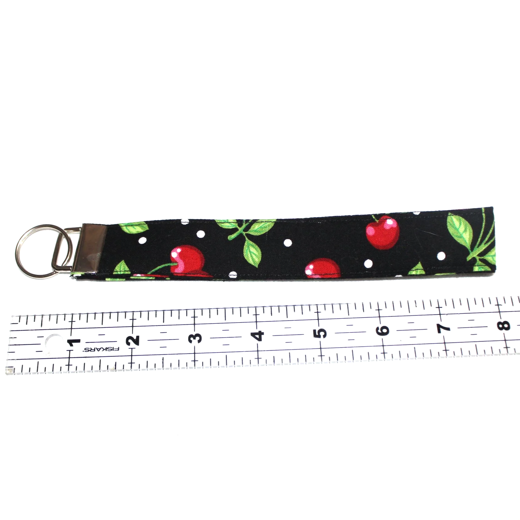 Close up view of the Scattered Cherry Wristlet shown above a ruler to show size.