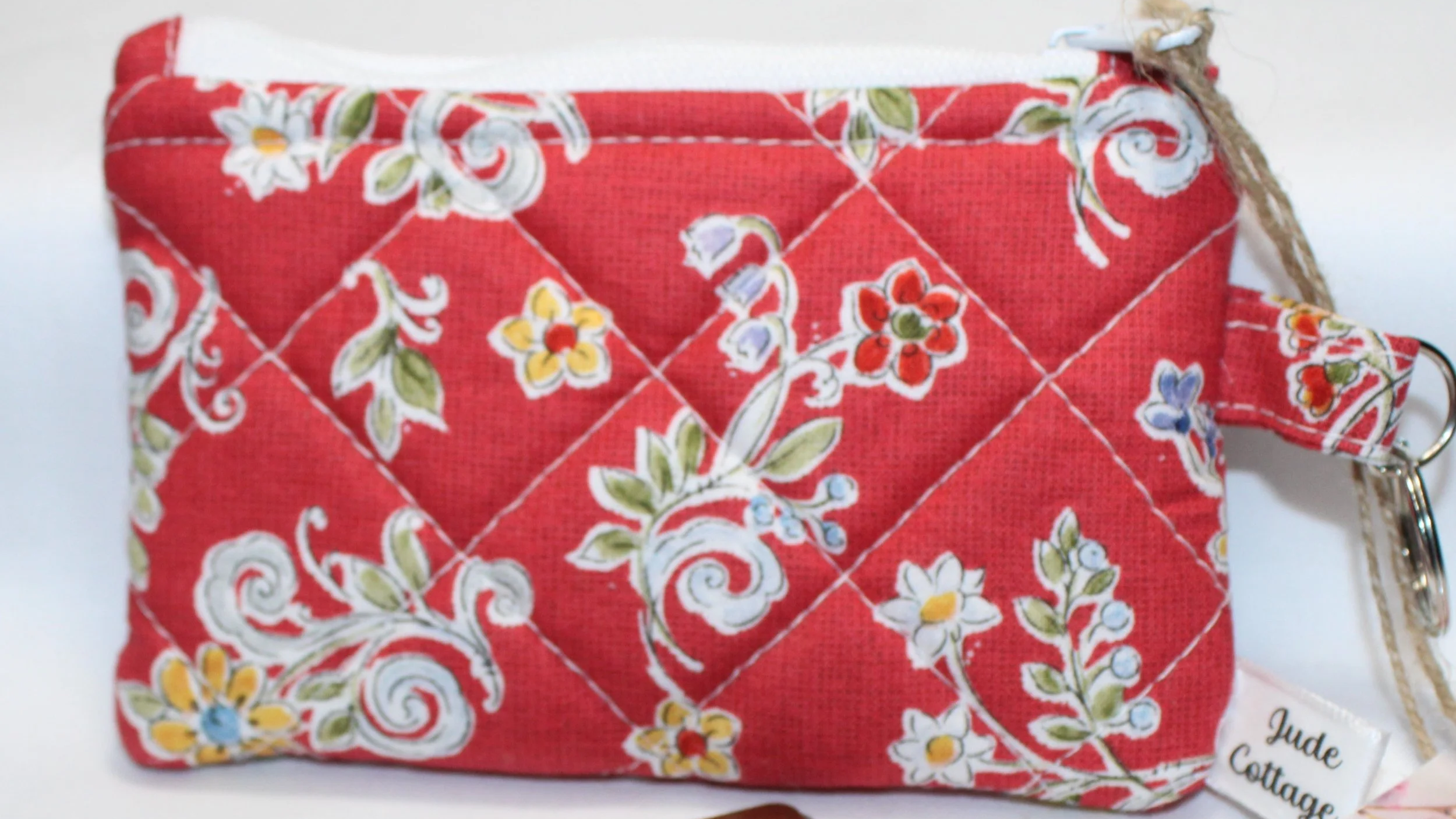 Red quilted keychain wallet with a summer floral pattern, zipper closure, and metal key ring.