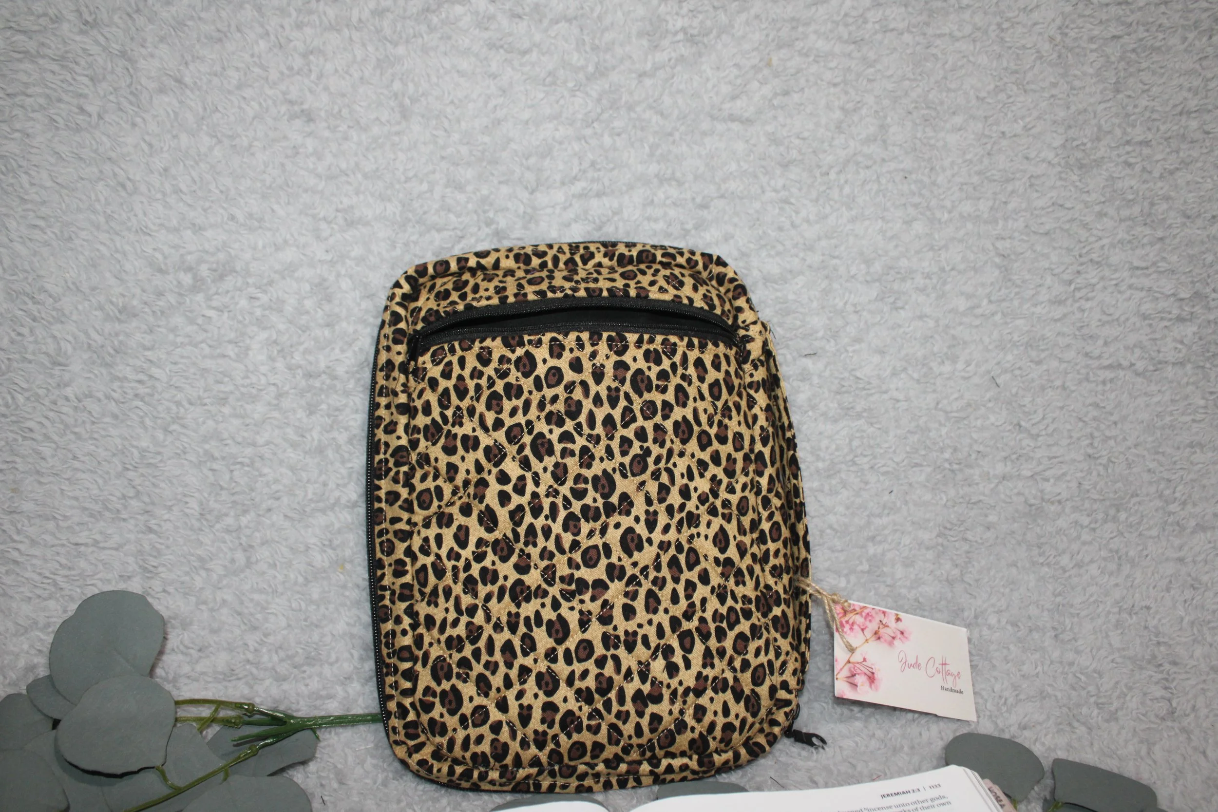 Back-facing view of the Sahara Study Bible Case featuring a neutral cheetah print with quilted exterior, shown upright with a back zippered pocket.