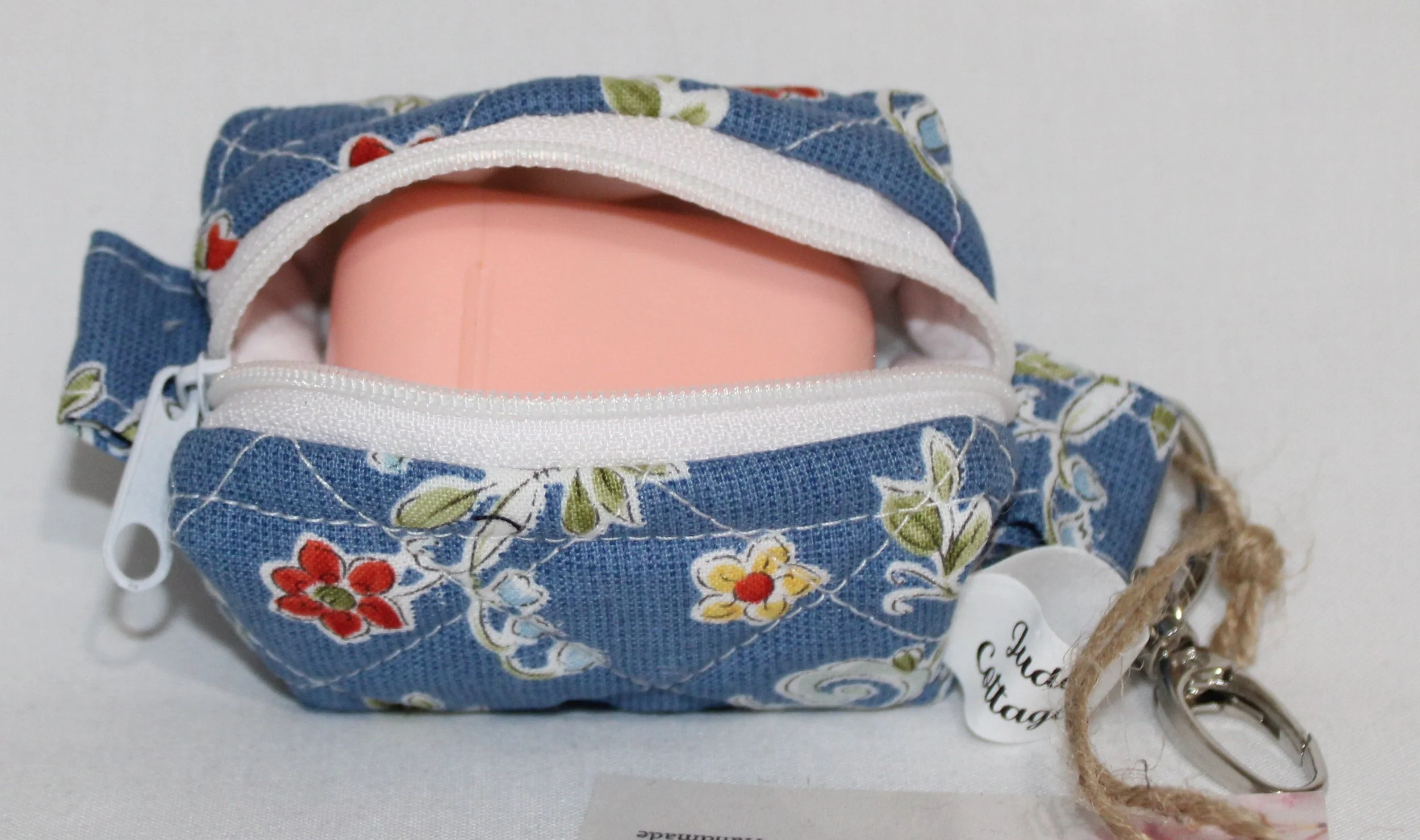 Open top view of the Liberty Blue Bag Charm with an Airpod earbud case inserted to show fit.