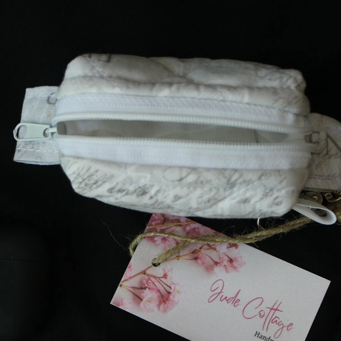 Top open view of the Faith Hope Love Bag Charm showing zip closure and white lining.