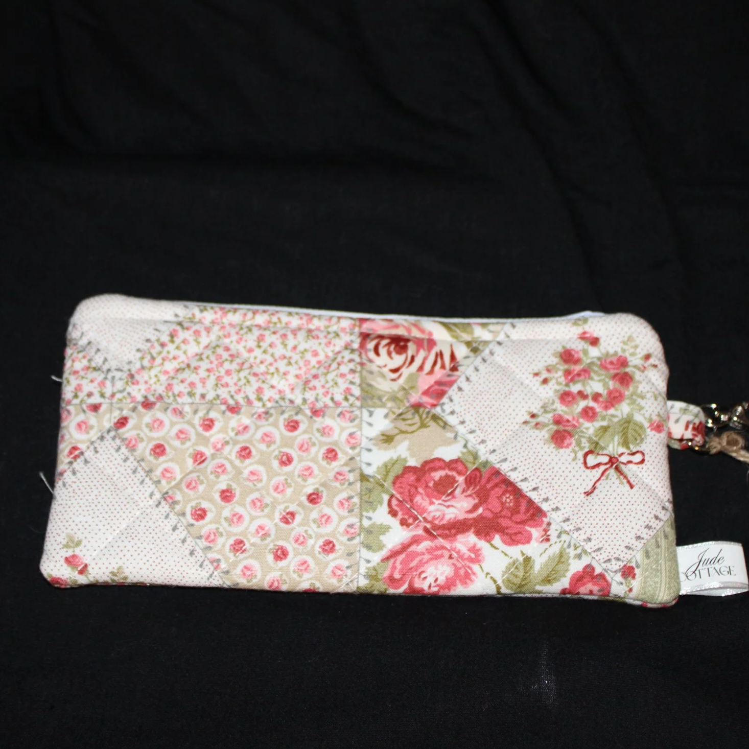 Front flat view of the Charity Large Keychain Wallet featuring a rose floral and sage green patchwork fabric.
