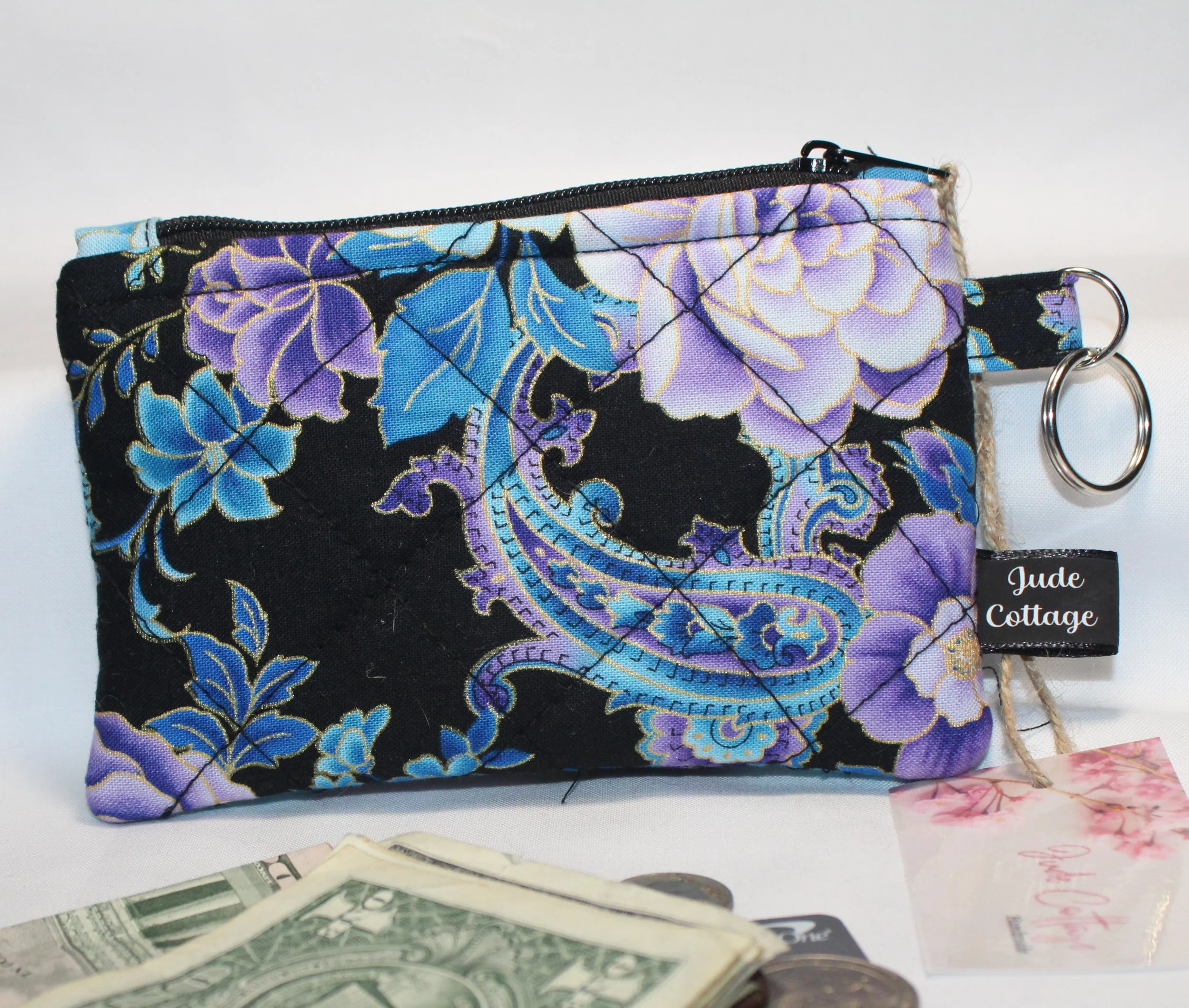Quilted keychain wallet with twilight paisley pattern, zipper closure, and metal key ring.