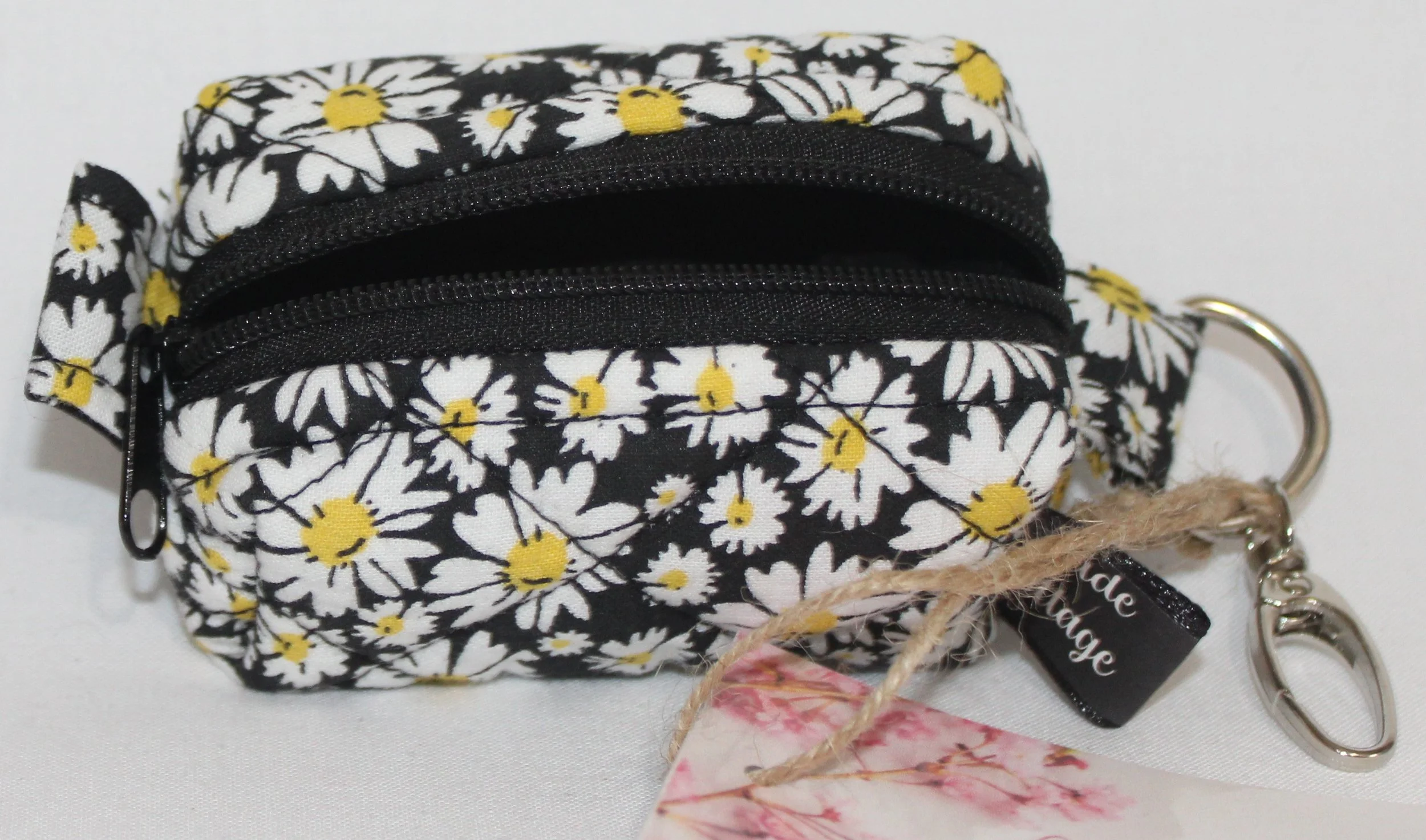 Top open view of the Ditzy Daisy Bag Charm showing zip enclosure and black lining.