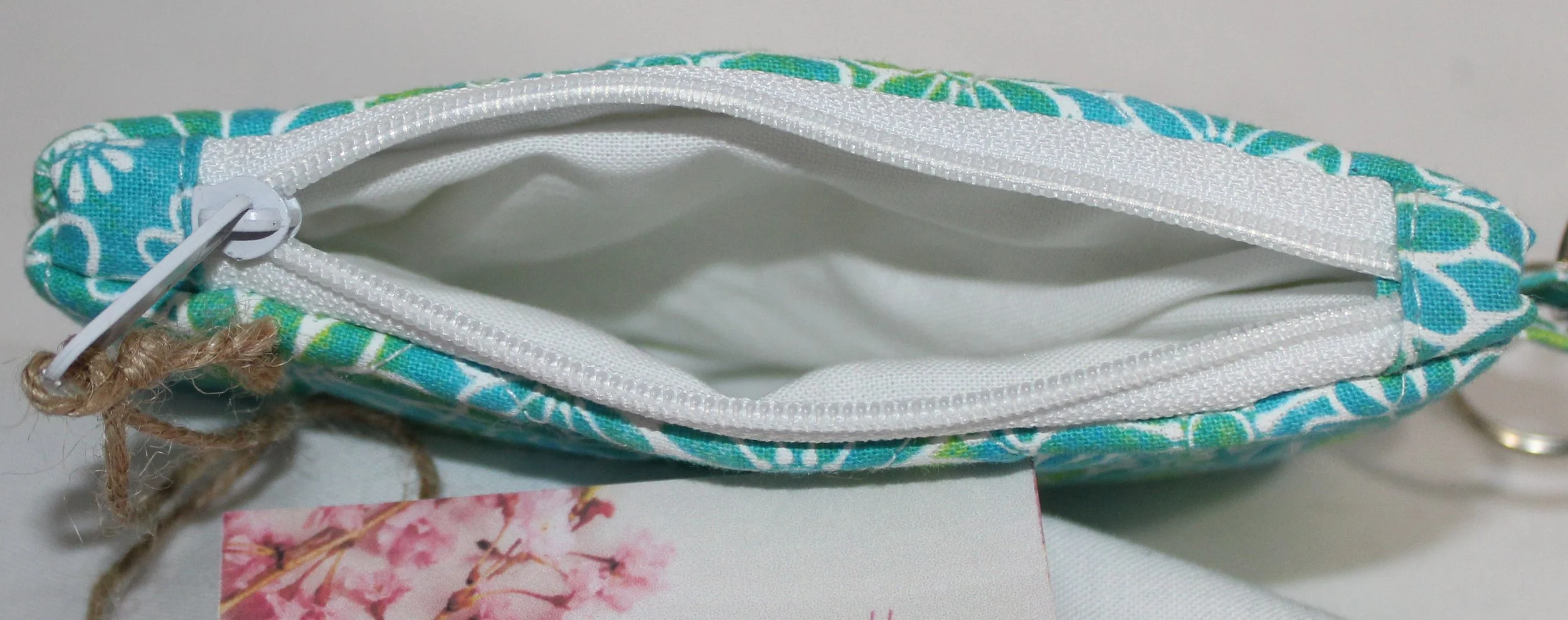 Top view of the Neon Daisy quilted keychain wallet showing the white lining and zipper.