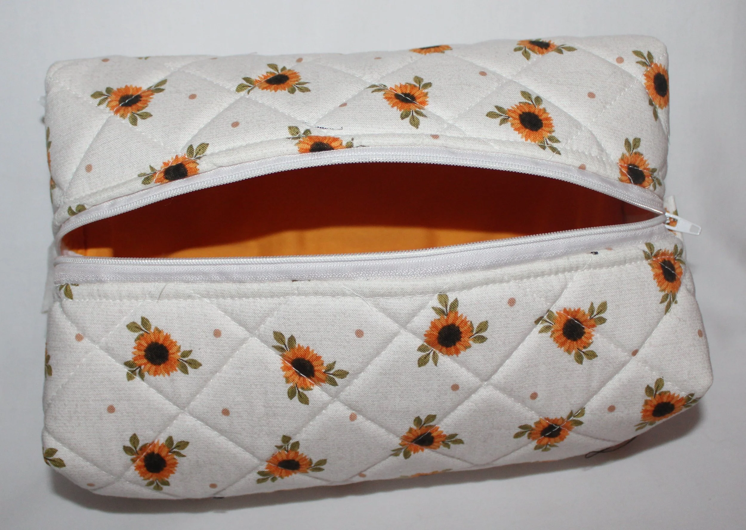 Top view of the open Sunflower Medley sunflower‑print quilted travel pouch showing the empty gold interior.