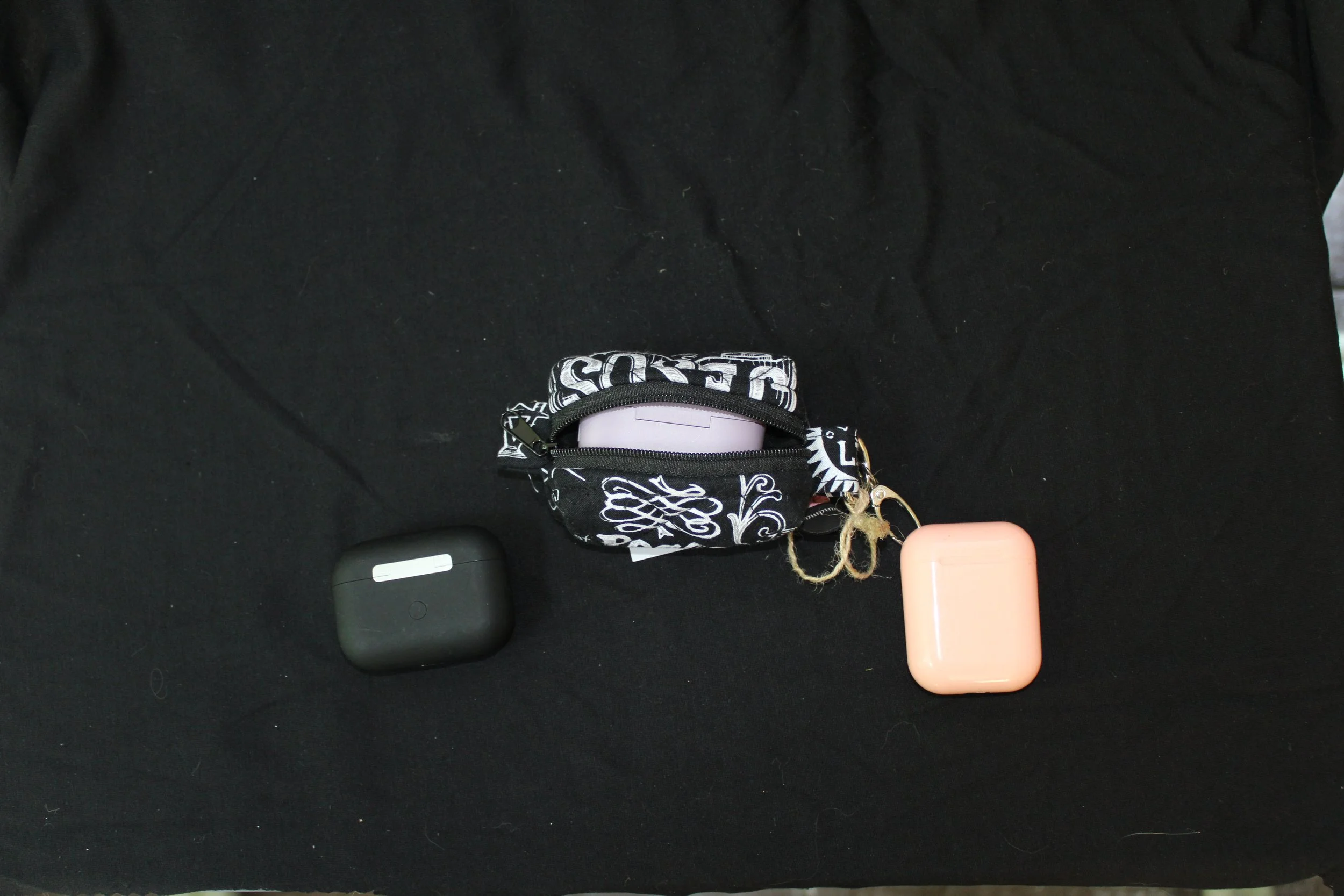 Top open view of the King of Kings Bag Charm with a J Lab earbud case inserted to show fit.