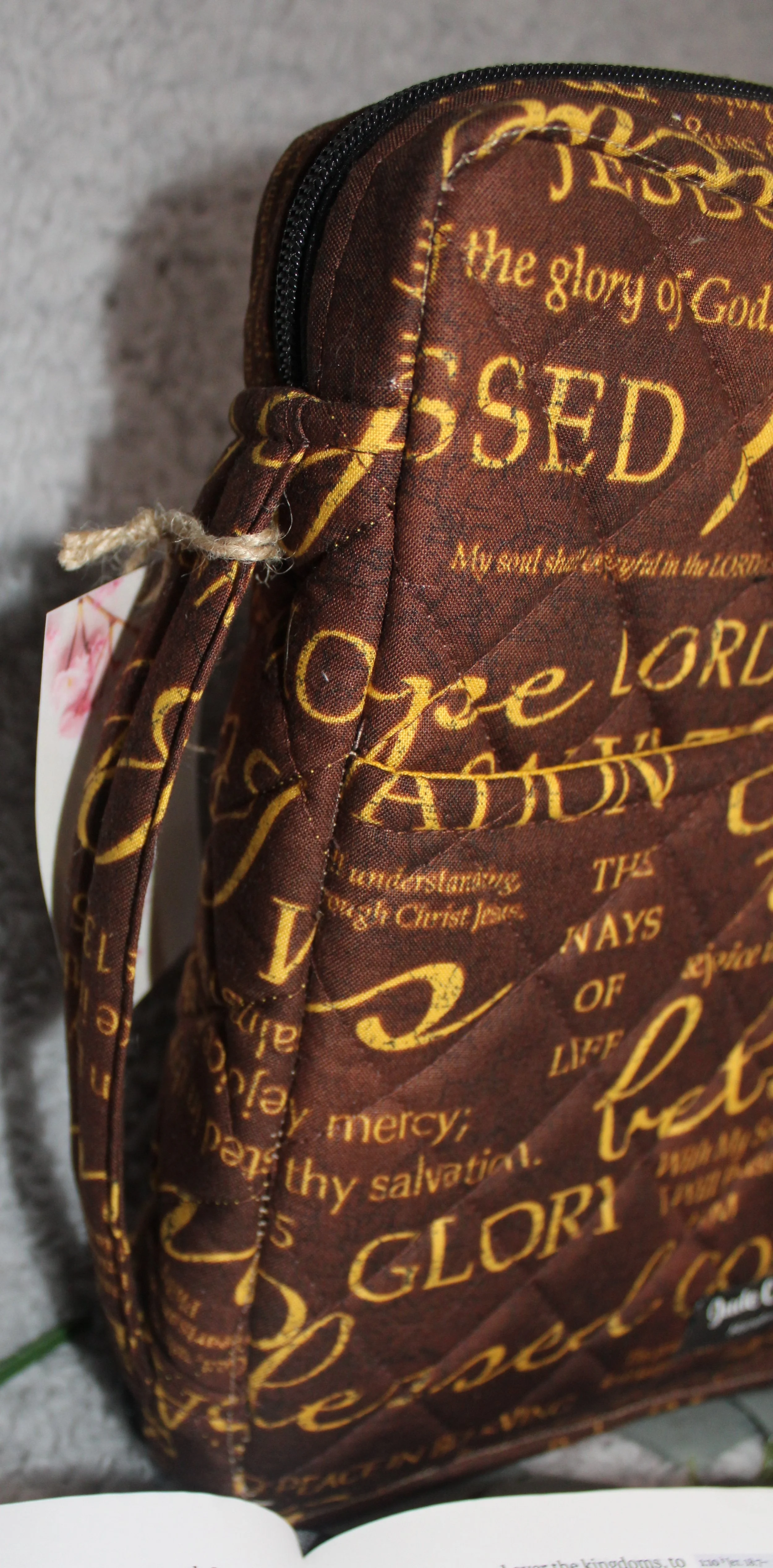 Side view of the Rejoice Study Bible Case showing the sturdy padded carry handle and the brown quilted exterior with gold inspirational religious wording visible along the edge.