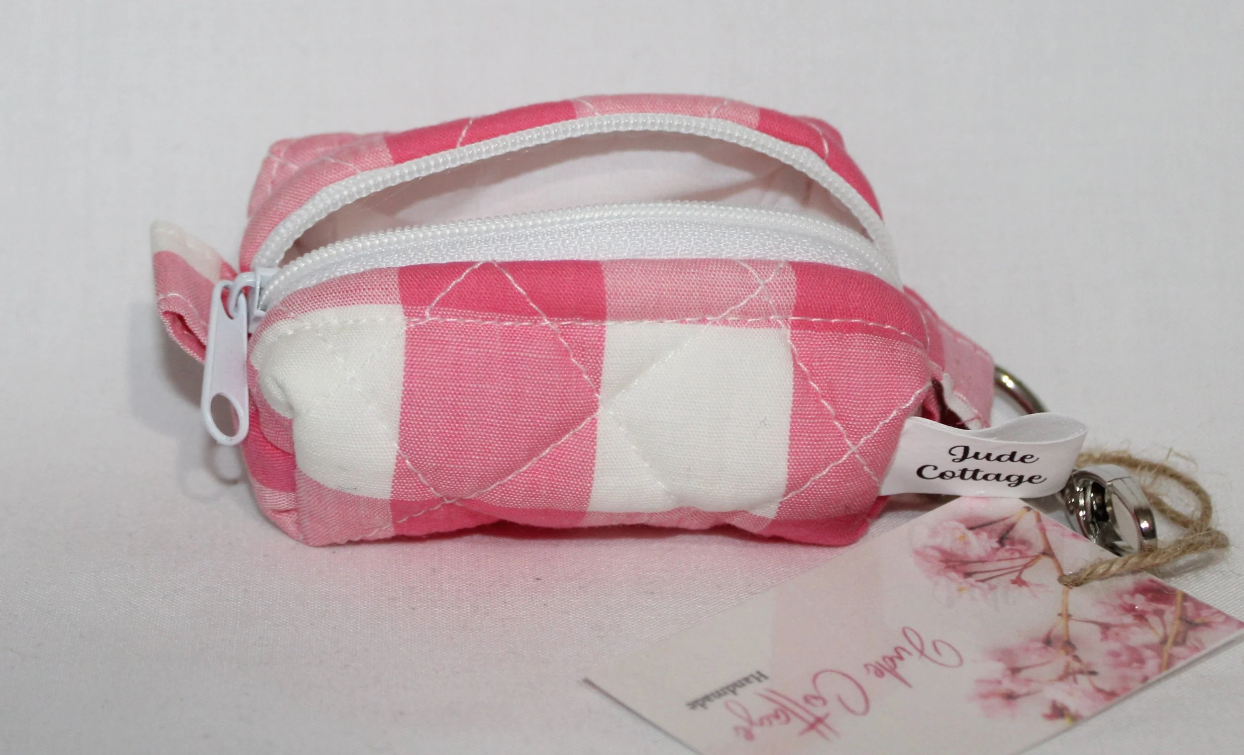 Top open view of the Sophie Bag Charm featuring a pink and white check fabric showing white zip closure and lining.