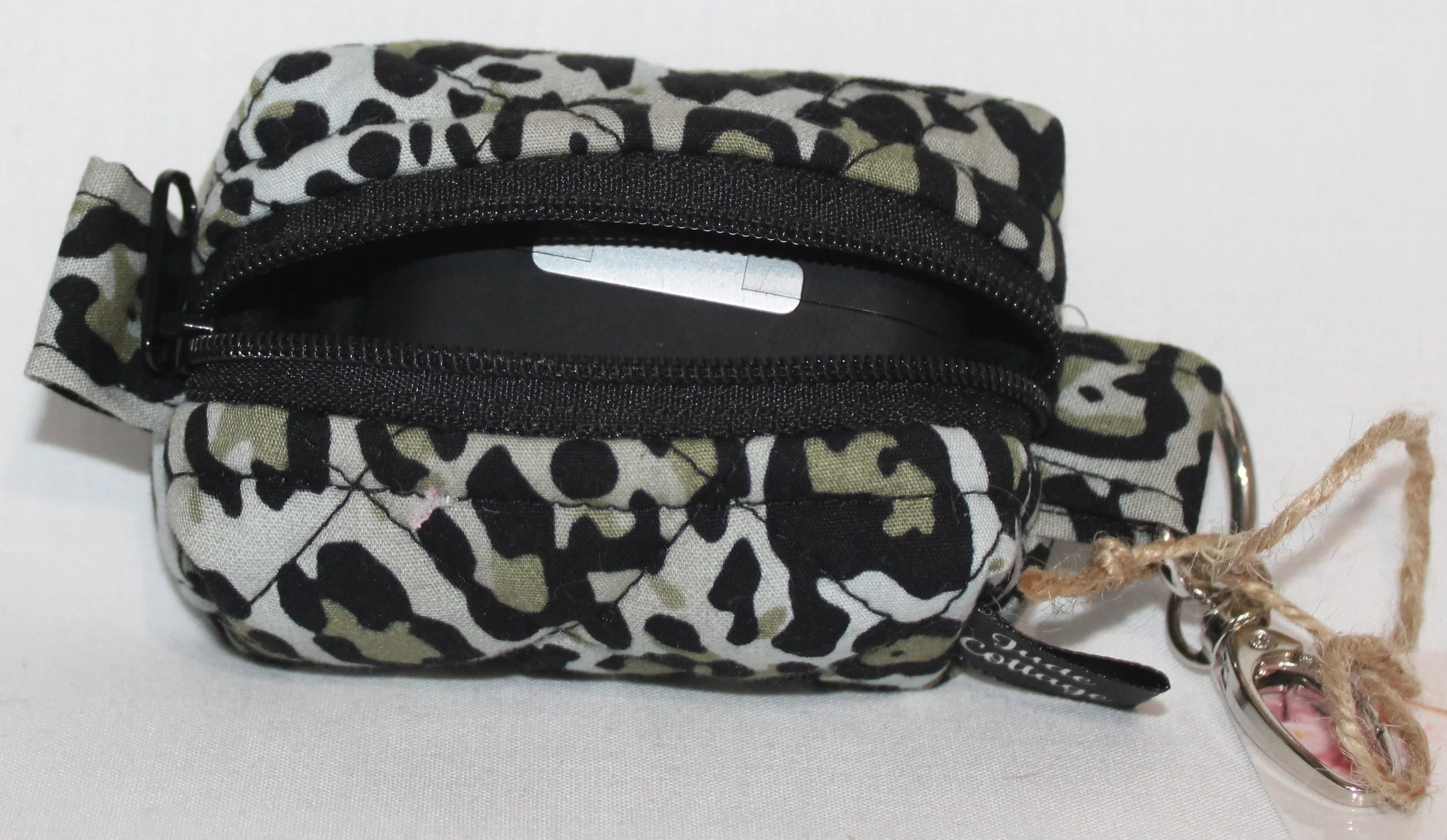 Open top view of the Diana Bag Charm featuring snow leopard print showing a set of Airpod Pro earbuds inserted for sizing.