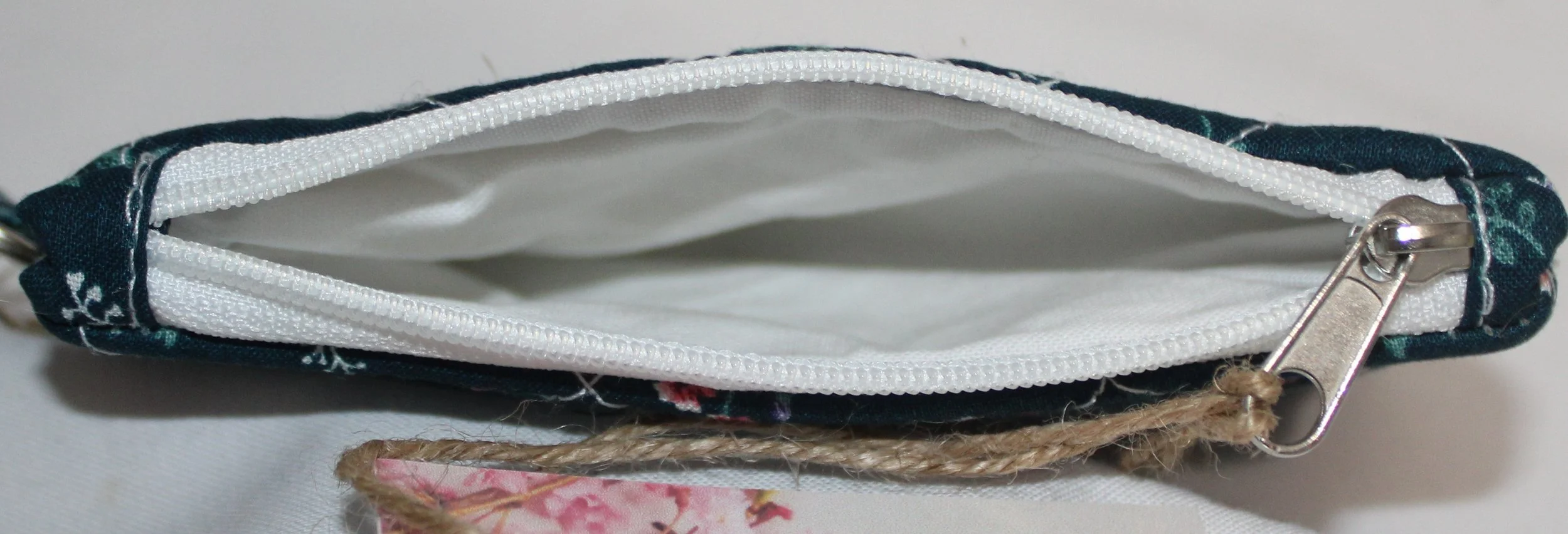 Top view quilted keychain wallet with Eliza pattern, zipper closure, and metal key ring.