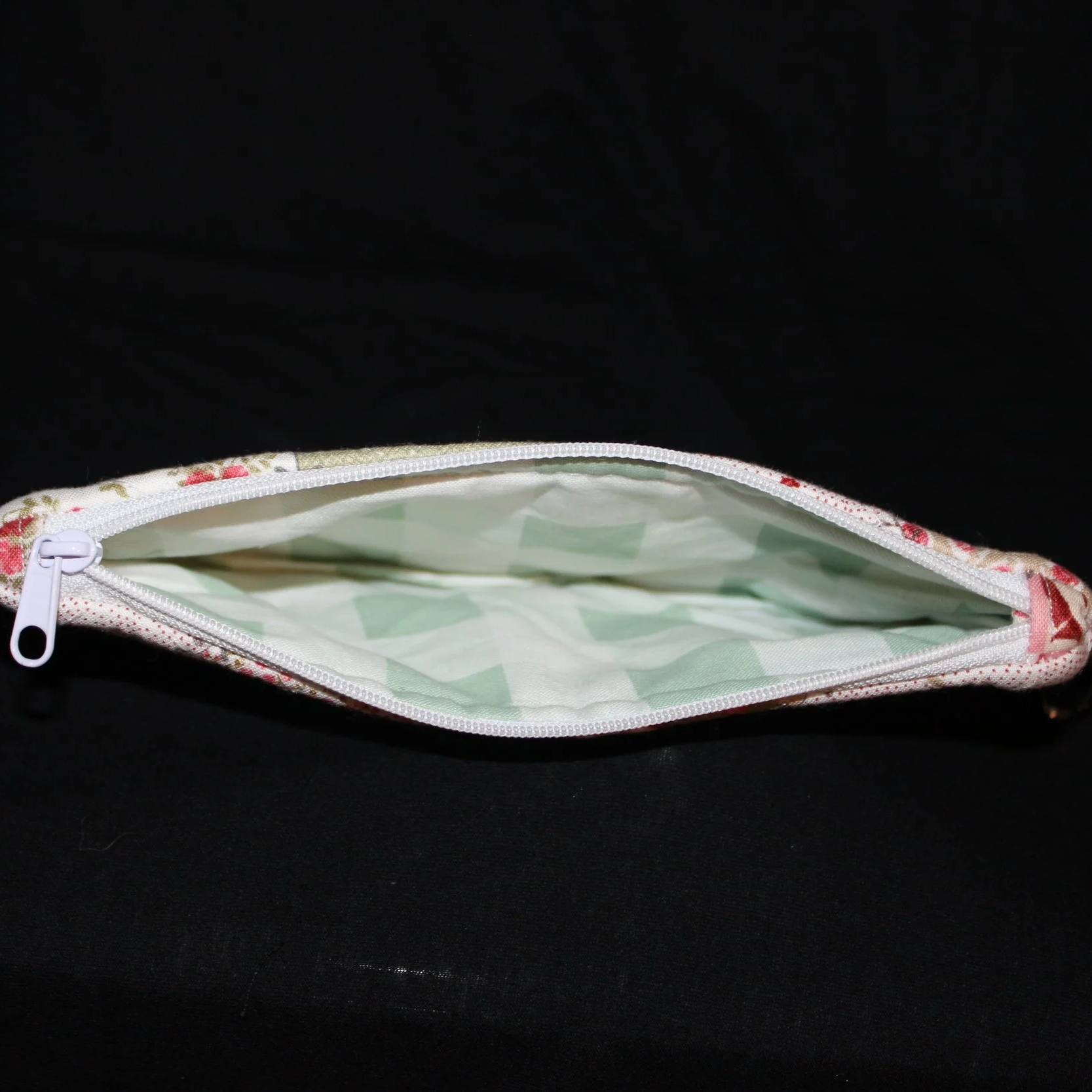 Top open view of the Charity Large Keychain Wallet showing white zip closure and sage and white buffalo print lining.