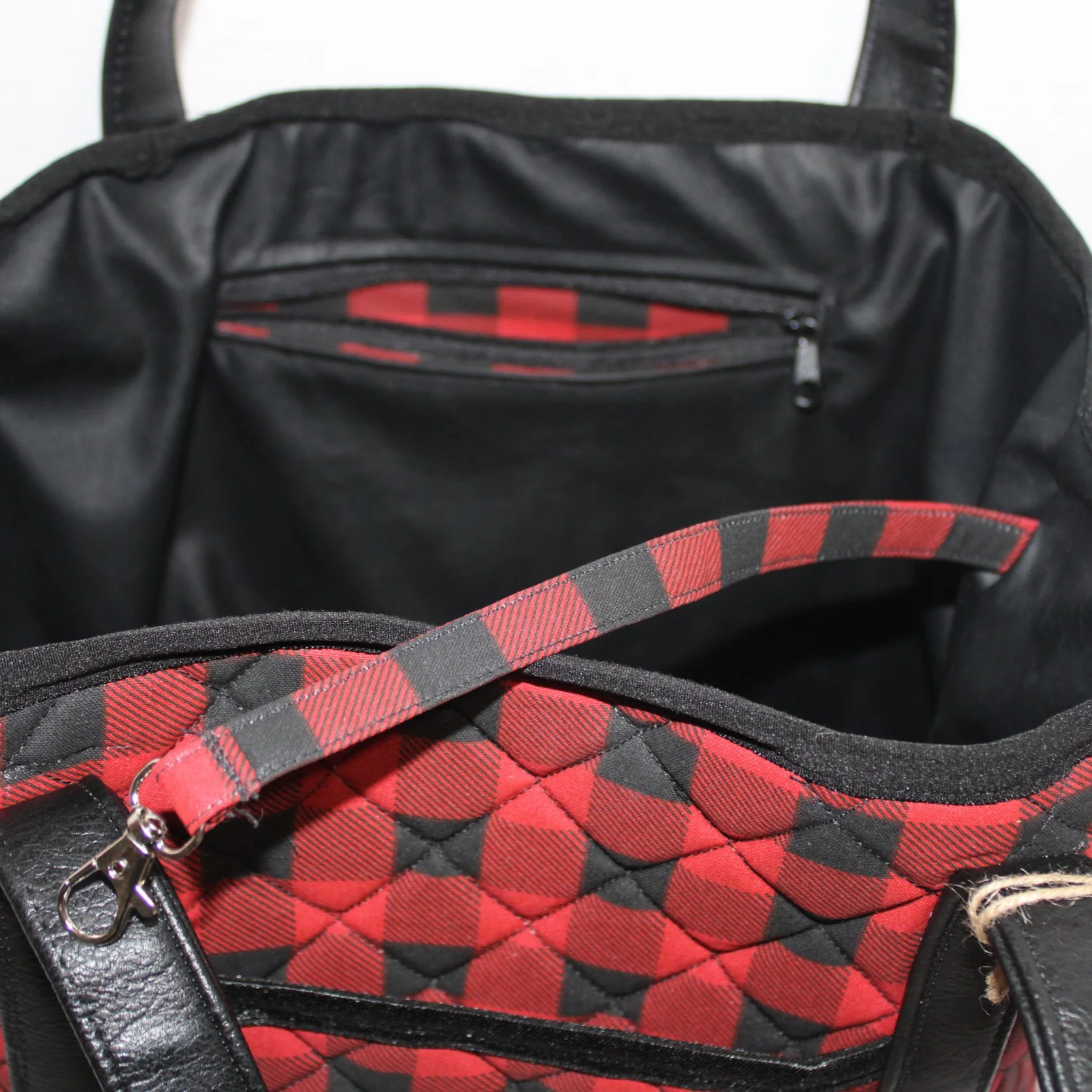 Up close view of the interior zip pocket, key strap, and faux leather lining.