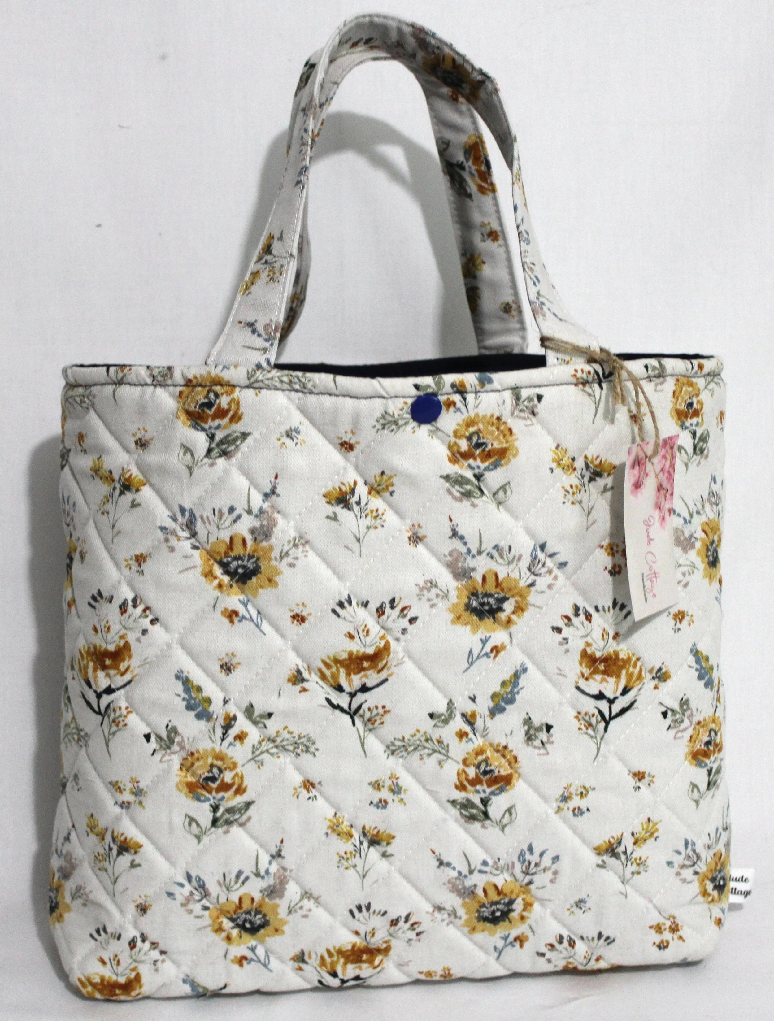 Front view of Dandelion Blue quilted Bible sleeve showing quilted texture, two handles, and snap closure.