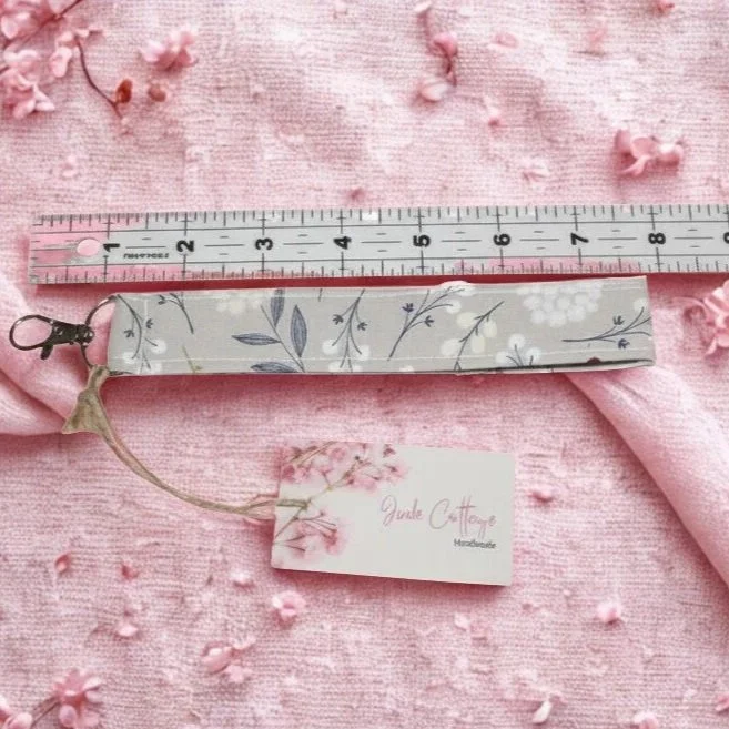 Dandelion Field Wristlet shown on a pink background below a ruler to demonstrate length.