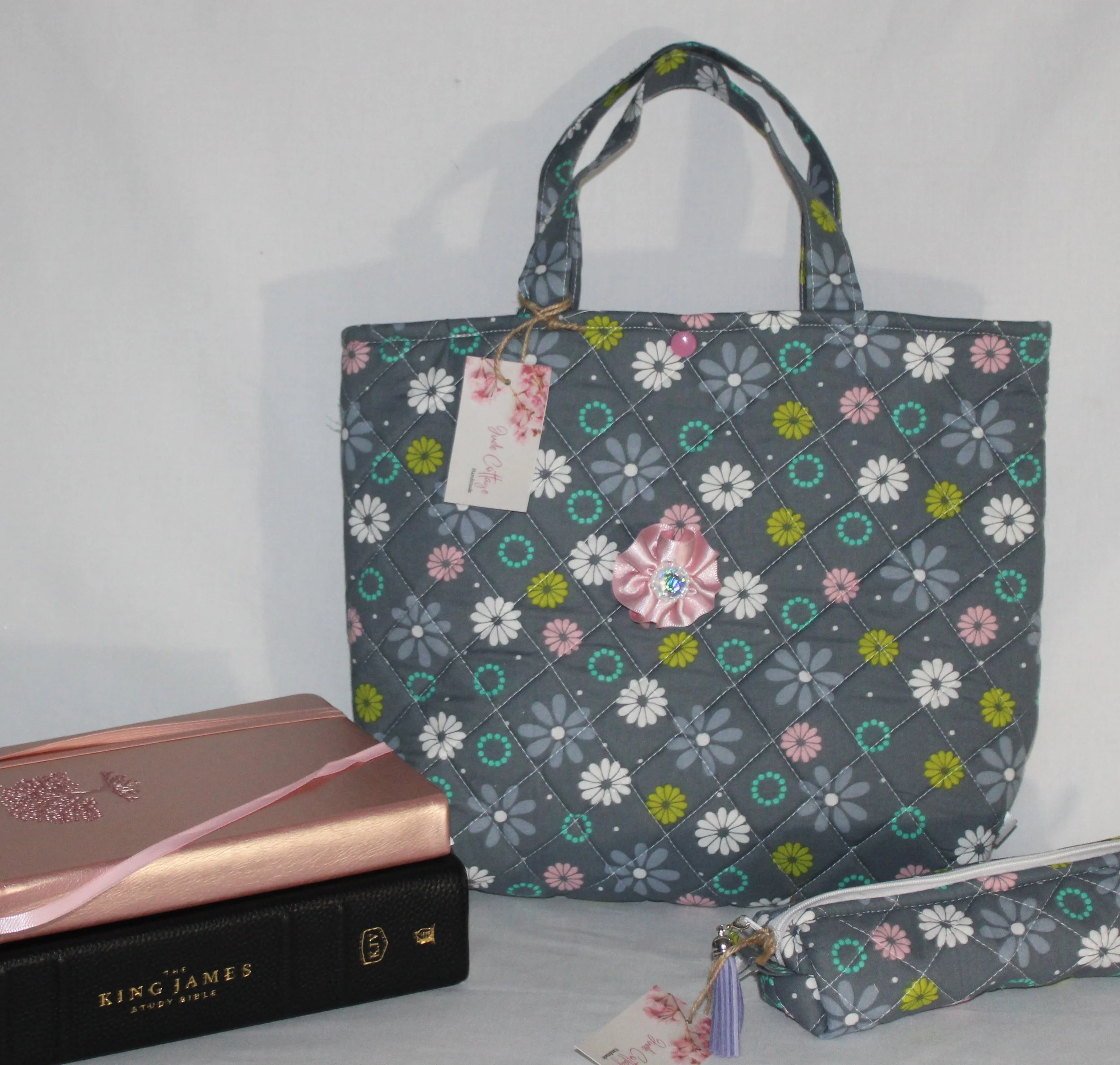 Floral quilted Bible tote bag displayed with a King James Bible and devotional book to show scale and intended use.