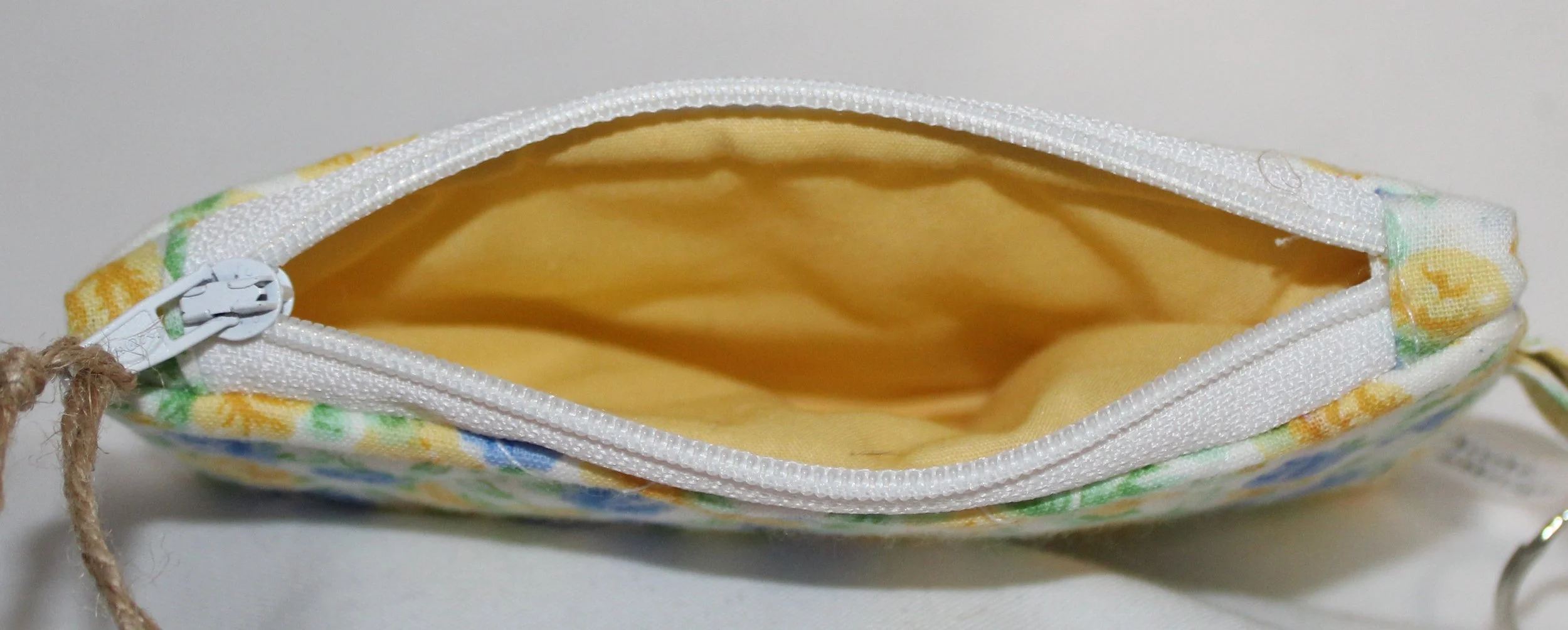 Top view quilted keychain wallet featuring dainty blue and yellow roses on white background, zipper closure, and metal key ring.