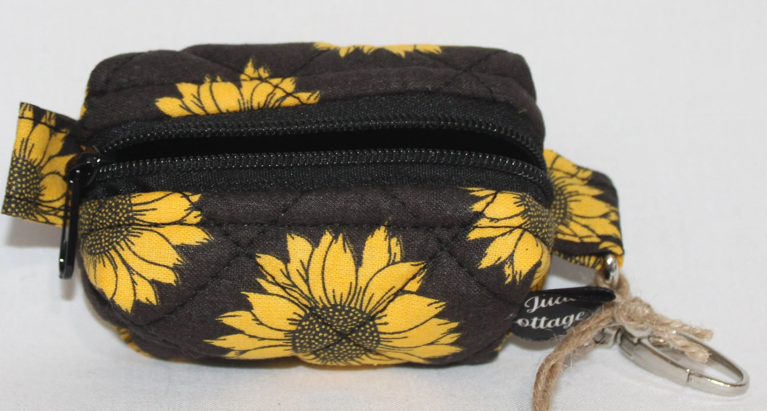 Top open view of the Midnight Sunflower Bag Charm featuring a black background fabric with bright golden yellow sunflowers, showing zip enclosure and a glimpse of black lining.