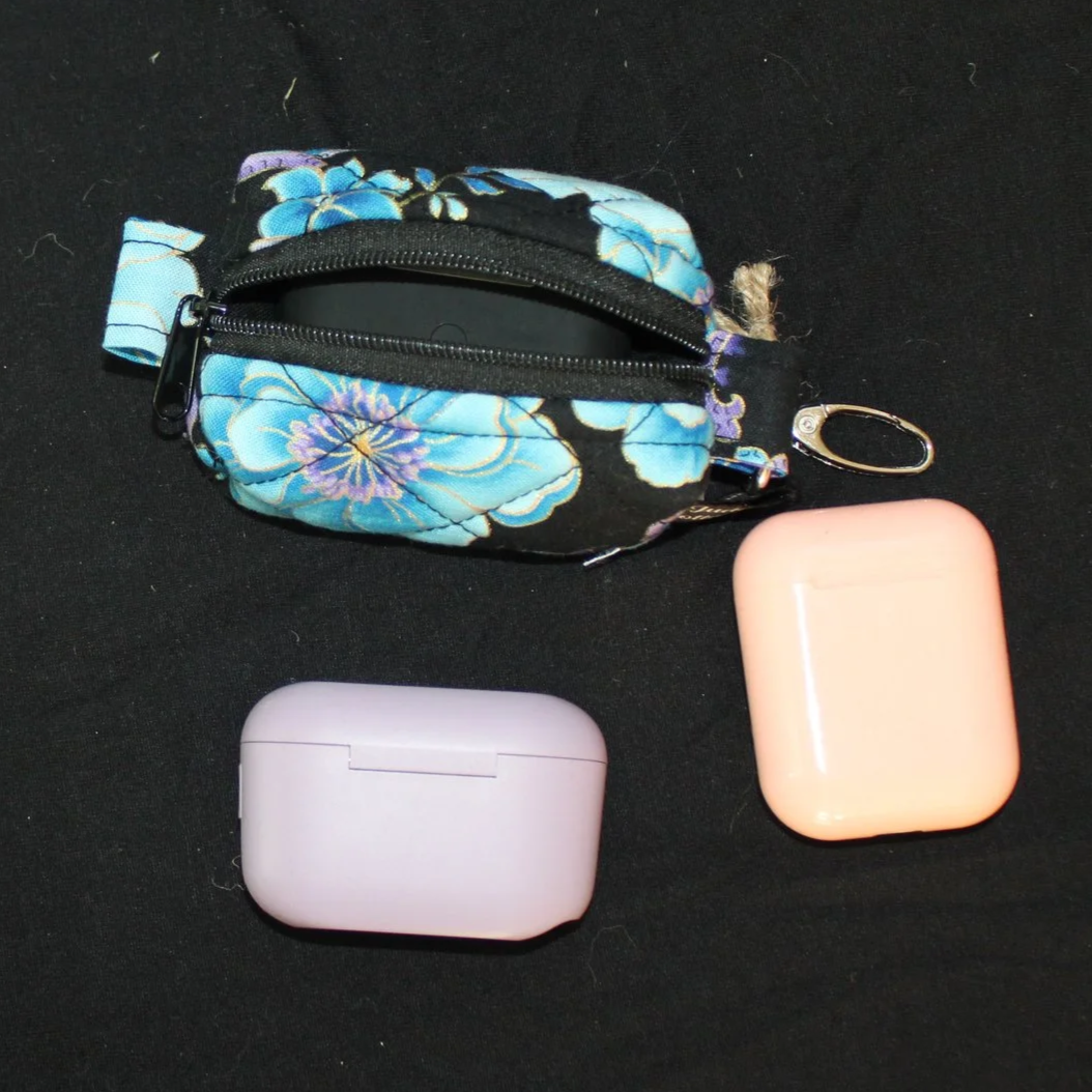 Top view of open zippered Twilight Paisley Bag Charm shown with airpod pro earbud case inserted for sizing reference.