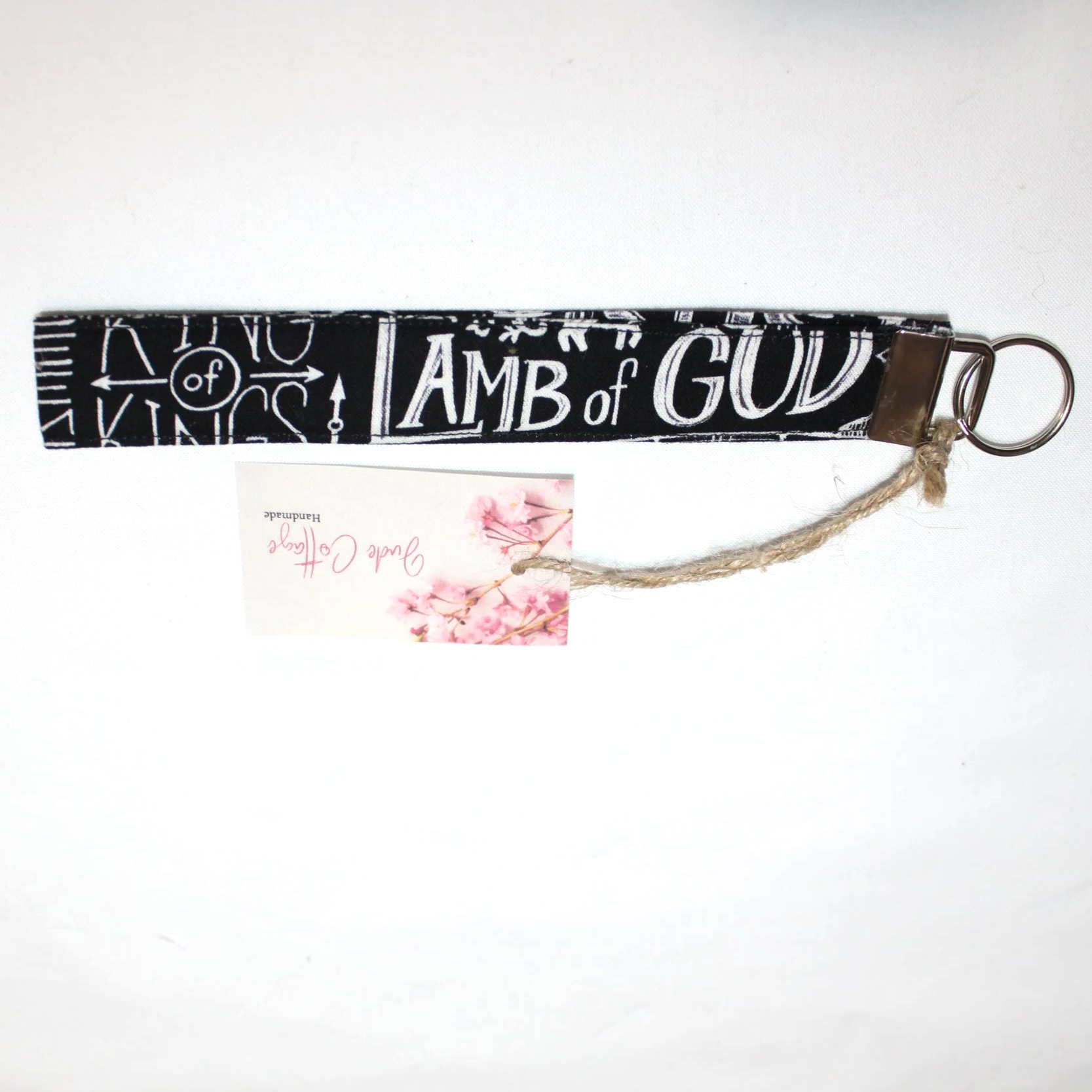 Close-up of the King of Kings Wristlet showing the keyfob hardware and religious names of Jesus print.