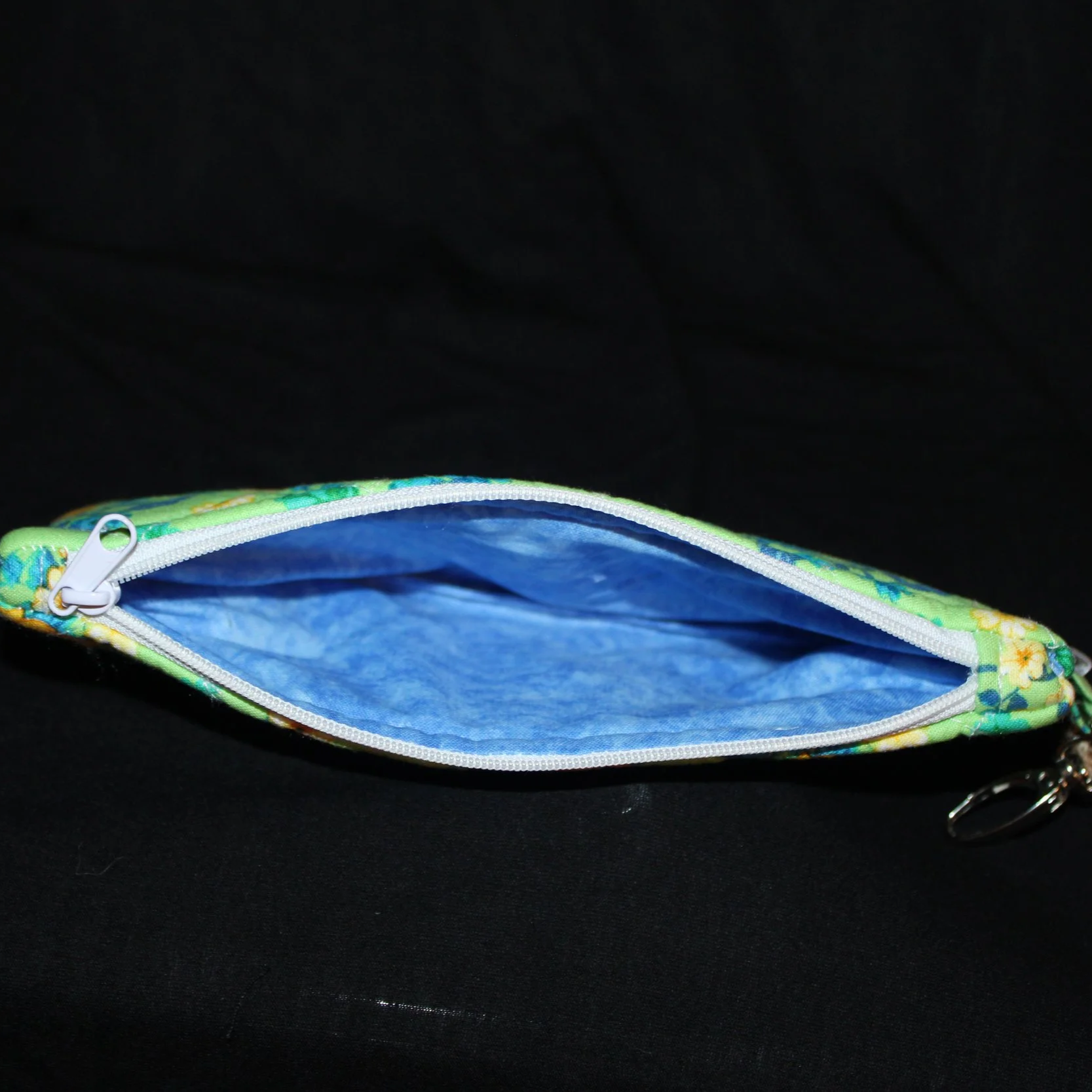 Top open view of the Suzanne Large Keychain Wallet showing the white zip closure and blue lining fabric.