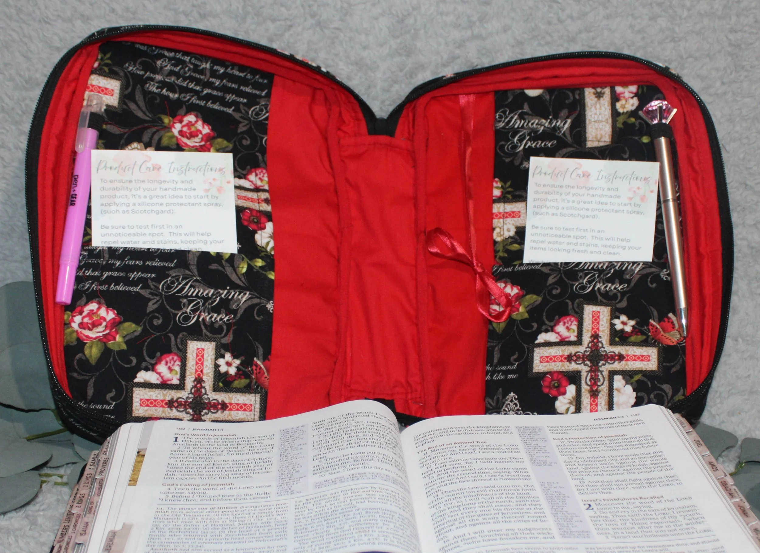 Interior view of the Amazing Grace Bible case without a Bible, showing the red interior lining, pens in the holders, and cards in the pockets.