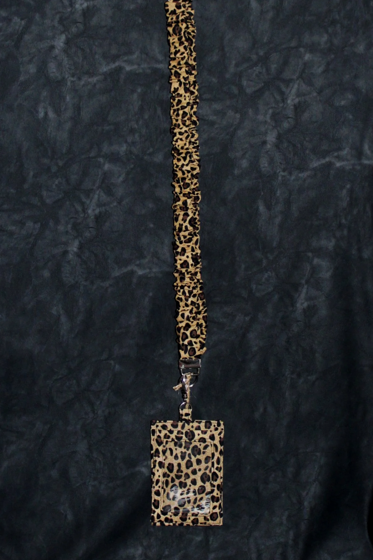 Hanging view of the Sahara Scrunch Lanyard and Badge holder, showing lanyard and matching ID holder in cheetah print fabric.