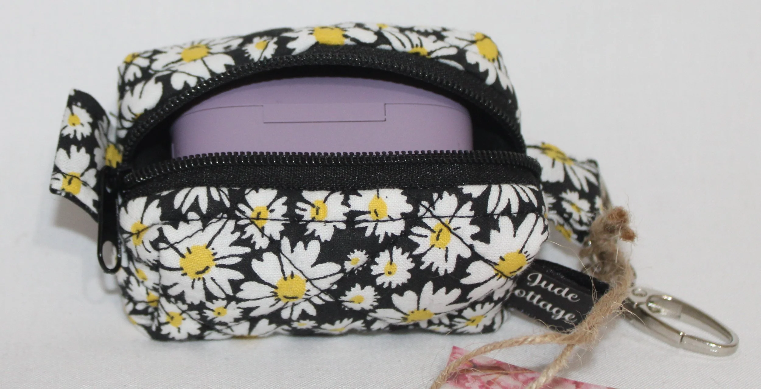 Top open view of the Ditzy Daisy Bag Charm showing zip enclosure and a J Lab case inserted for size reference.
