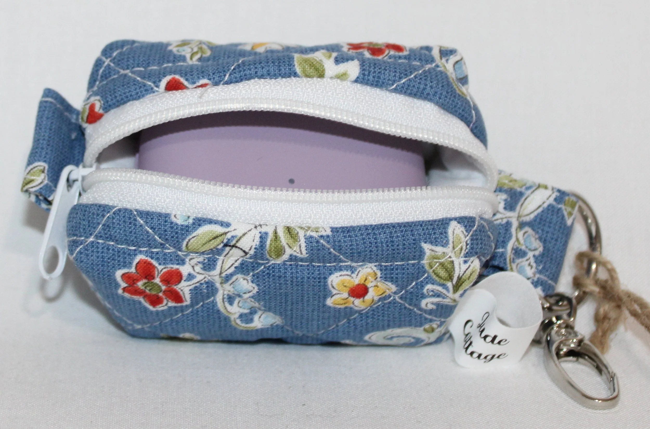 Open top view of the Liberty Blue Bag Charm with a J Lab earbud case inserted to show fit.