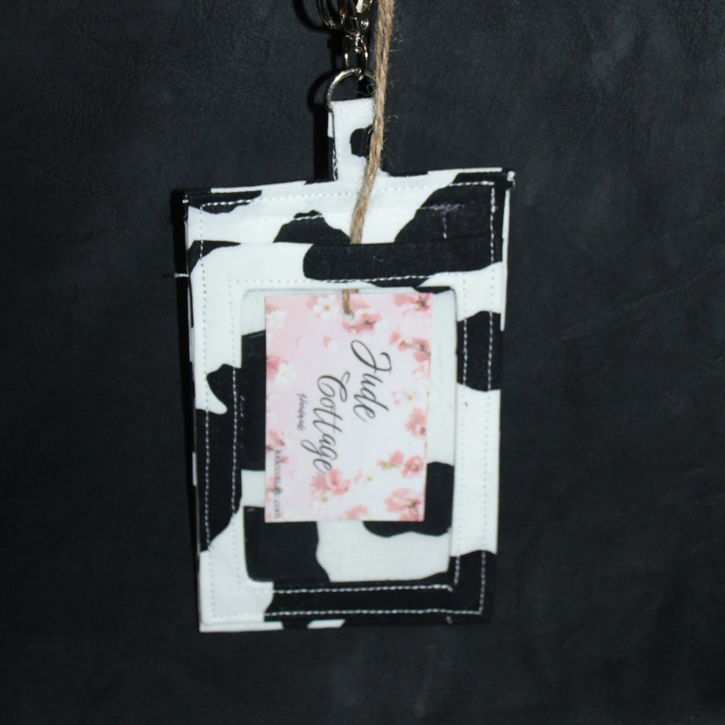 Front view of the Black Cow Badge Holder with a card inserted to illustrate clear ID slot.