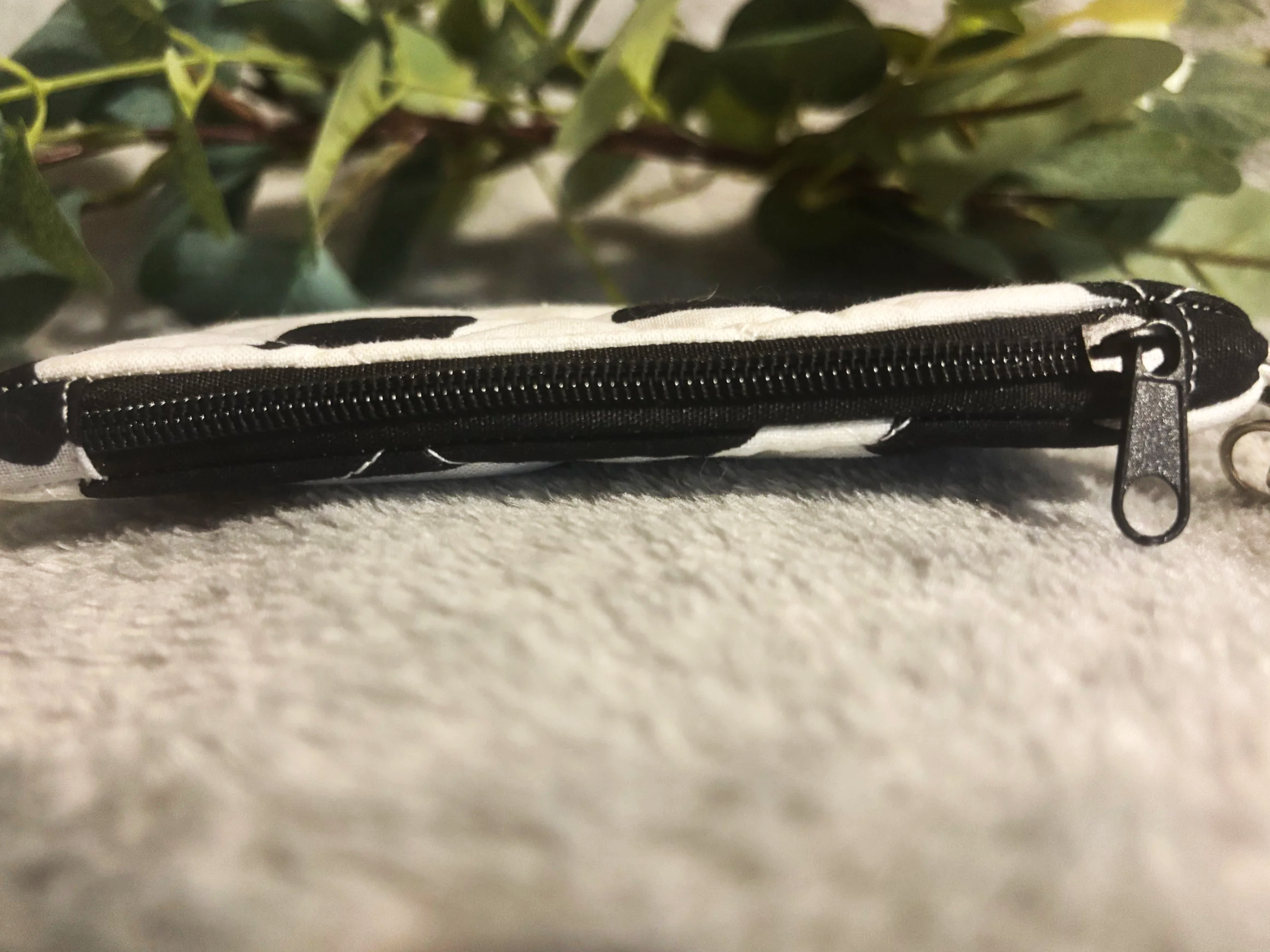 Top closed view of the Black Cow keychain wallet showing zip closure.