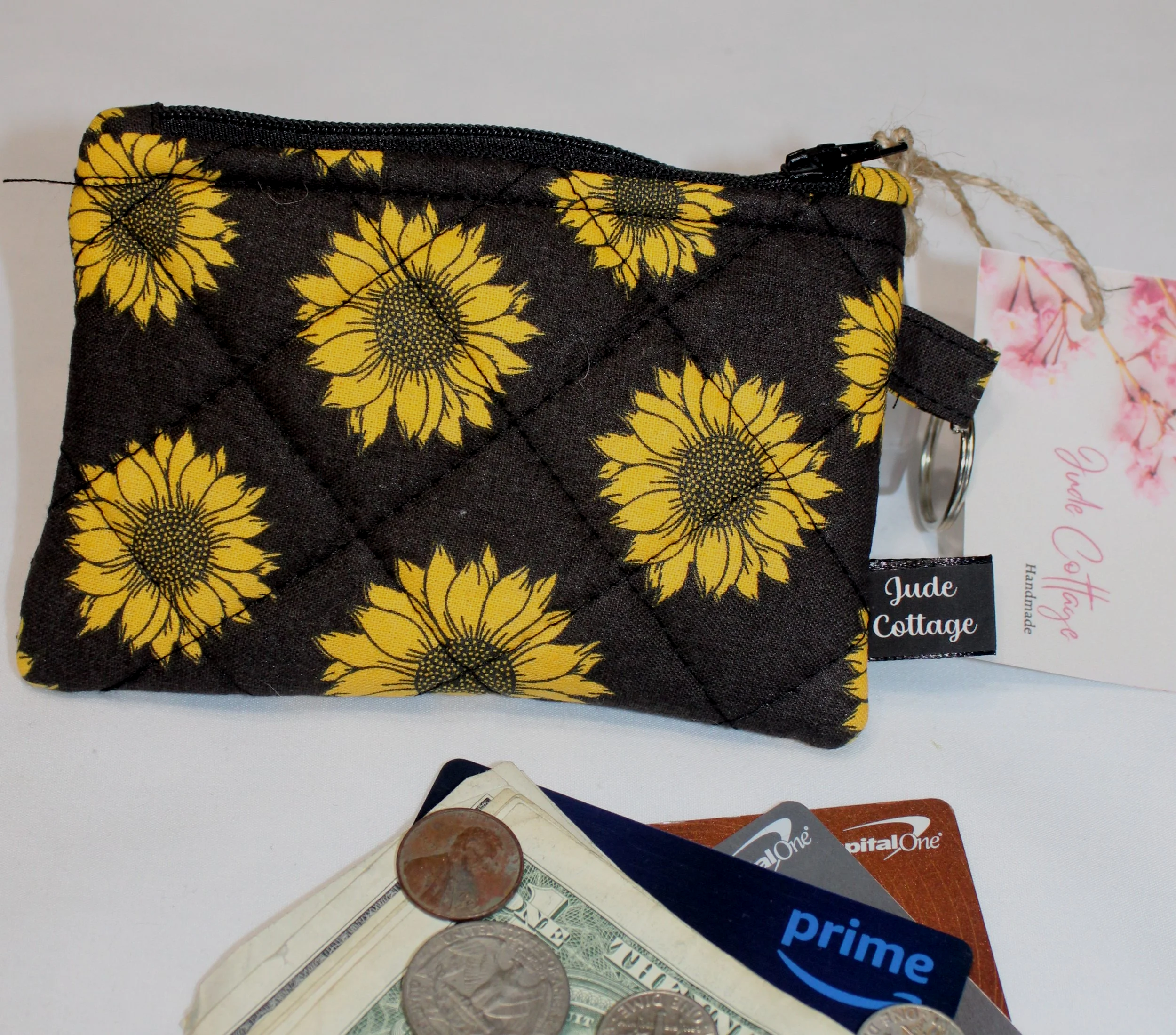 Dark quilted keychain wallet with bright sunflower pattern, zipper closure, and metal key ring.