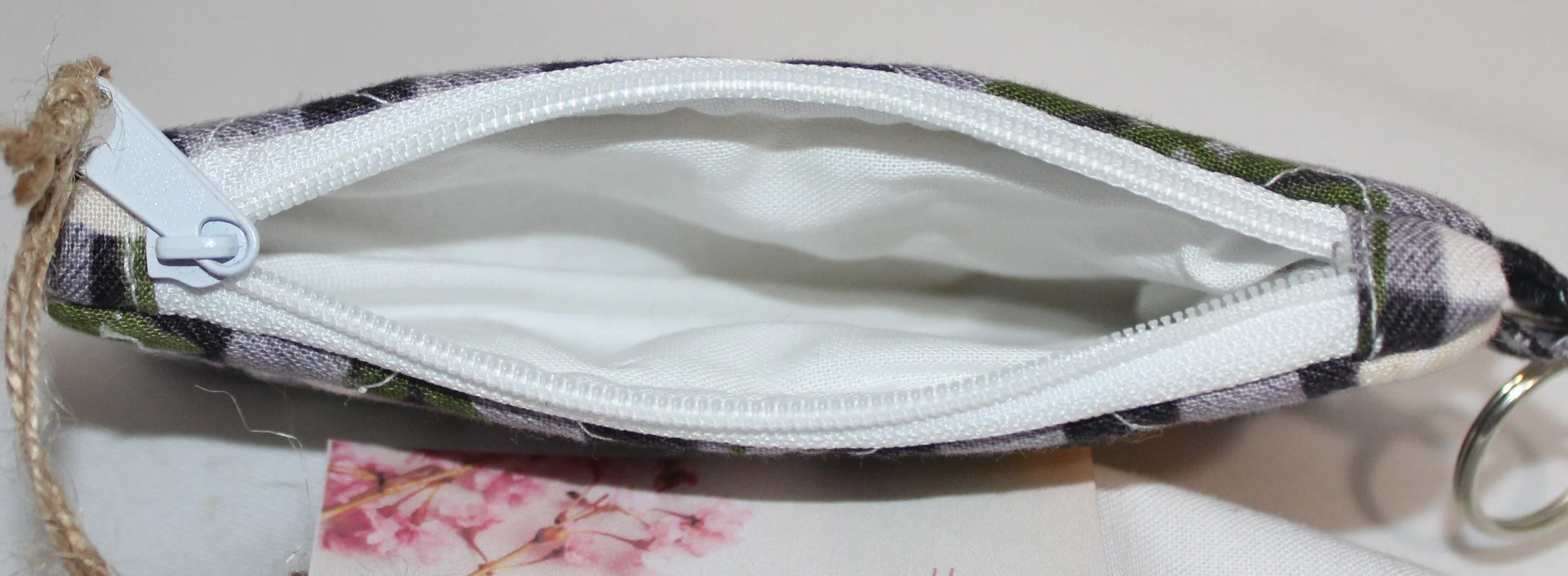 Top view quilted keychain wallet with Camilla floral pattern, zipper closure, and metal key ring.